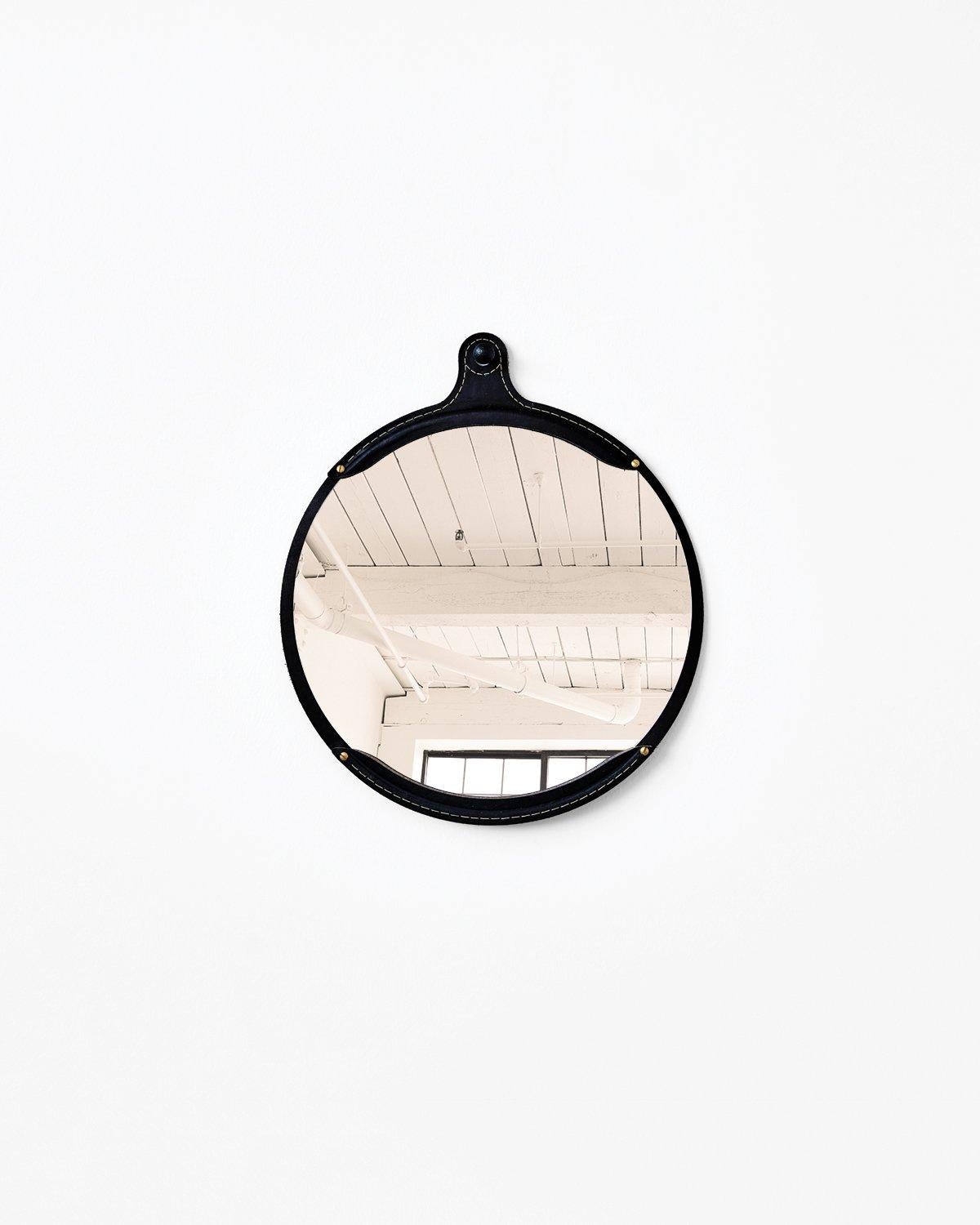 The Fairmount wide oval mirror is a hand-stitched leather mirror with a frame made from natural vegetable tanned leather which will vary in color and darken slightly with age. The mirror sits inside the frame like a pocket. It comes with an iron