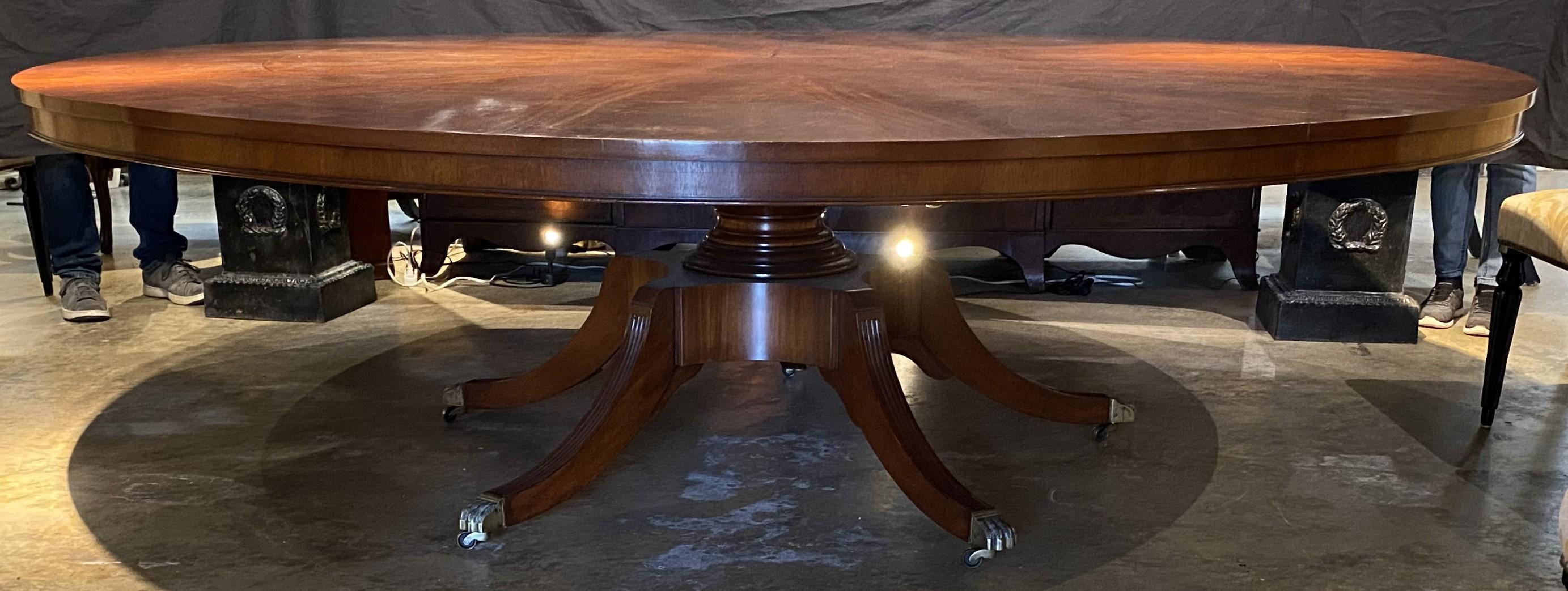 A wonderful round Jupe style dining table in figured mahogany with a center star inlay decoration and five deploying leaves around the diameter of the table with pull out numbered supports, and a nicely turned pedestal base with four out-swept legs,
