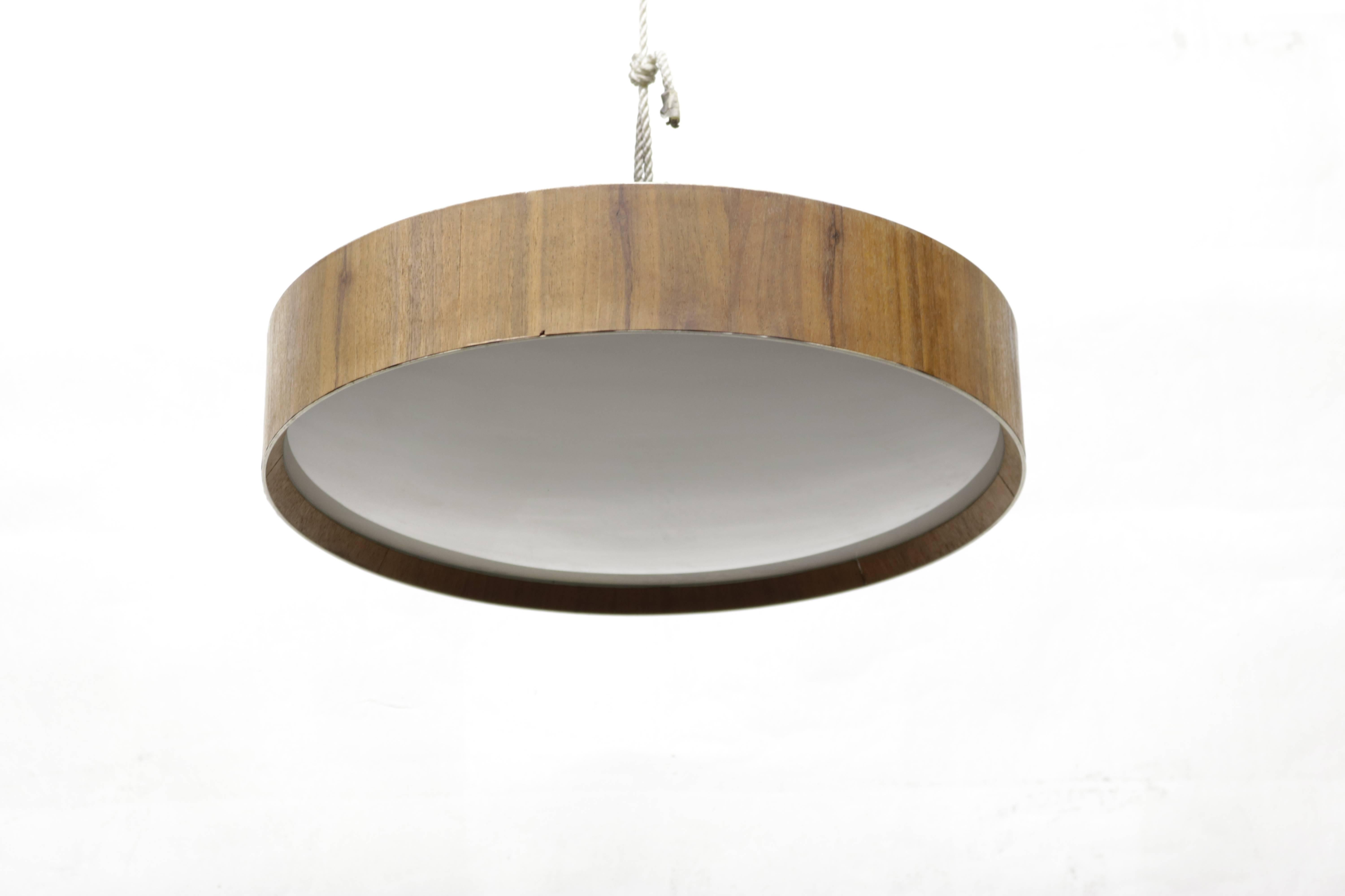 Round flush mount lighting fixture with wood trim and frosted glass diffuser.