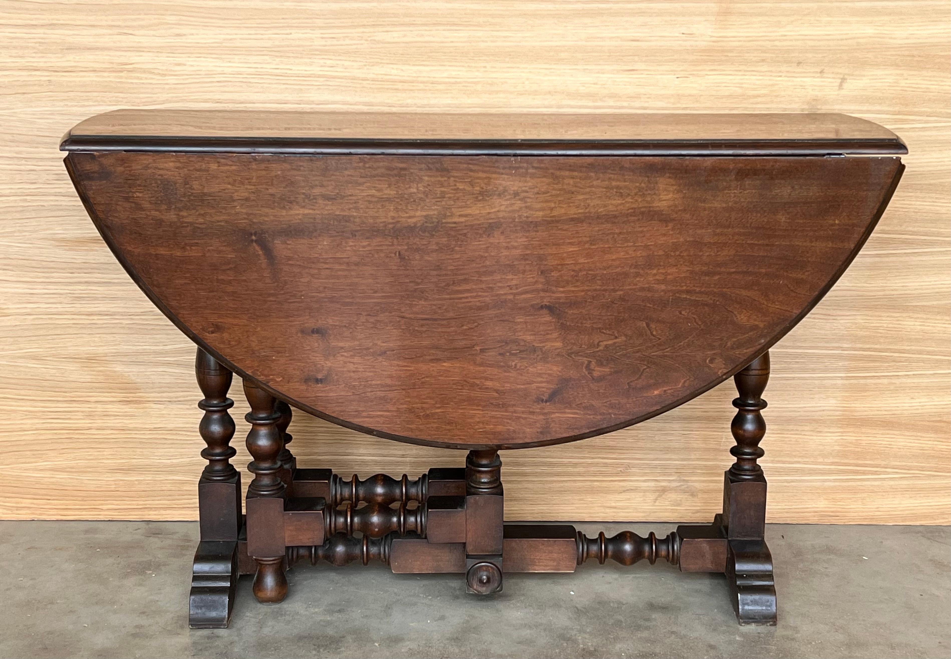 Round Folding oak side table with turned legs and beveled top . The table has four legs and stretchers between the legs to reinforce the stability .
Restored and very functional piece.