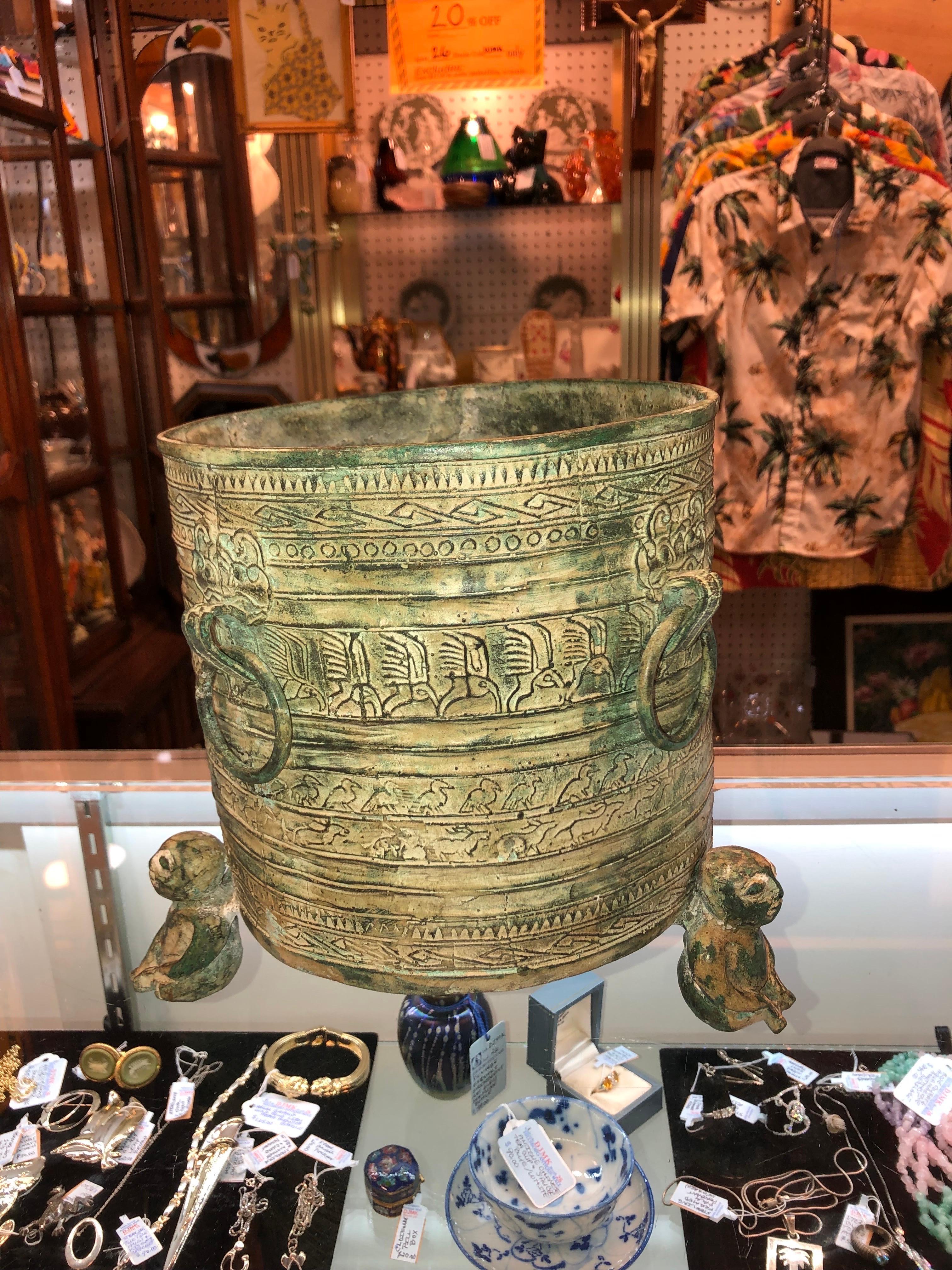 Round Footed Asian Bronze Finished Planter
three monkeys holding pot, four rings around.
Thick brass edged with figures of birds, symbols and Greek key pattern.
Very heavy.
Size: 8.25