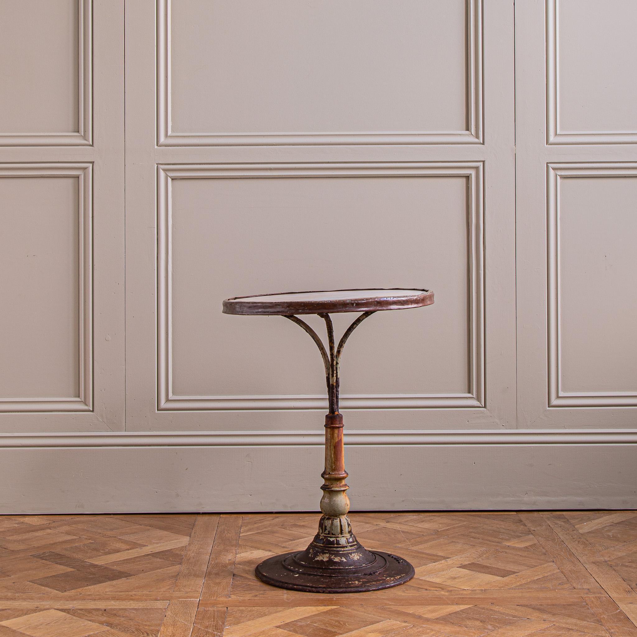 A French cast iron bistro table from the turn of the 20th century with lots of character and charm. The beautifully cast iron pedestal, featuring attention to detailing in its moulding, still has a degree of the original old paintwork which is now a