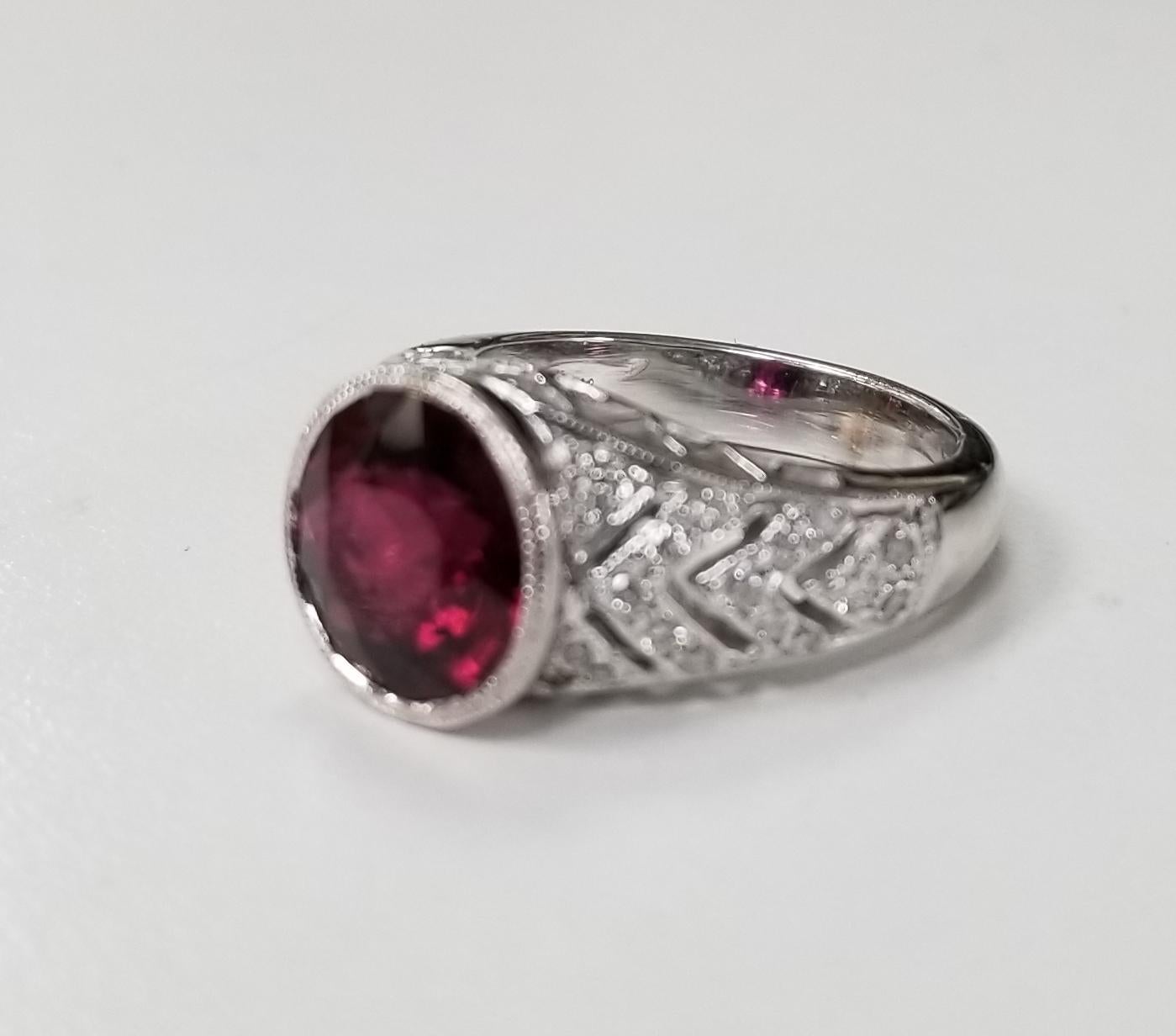 14k white gold garnet and diamond ring, containing 1 round garnet of gem quality weighing 2.98cts. and 38 round full cut diamonds weighing .45pts.  This ring is a size 5.5 but we will size to fit for free.