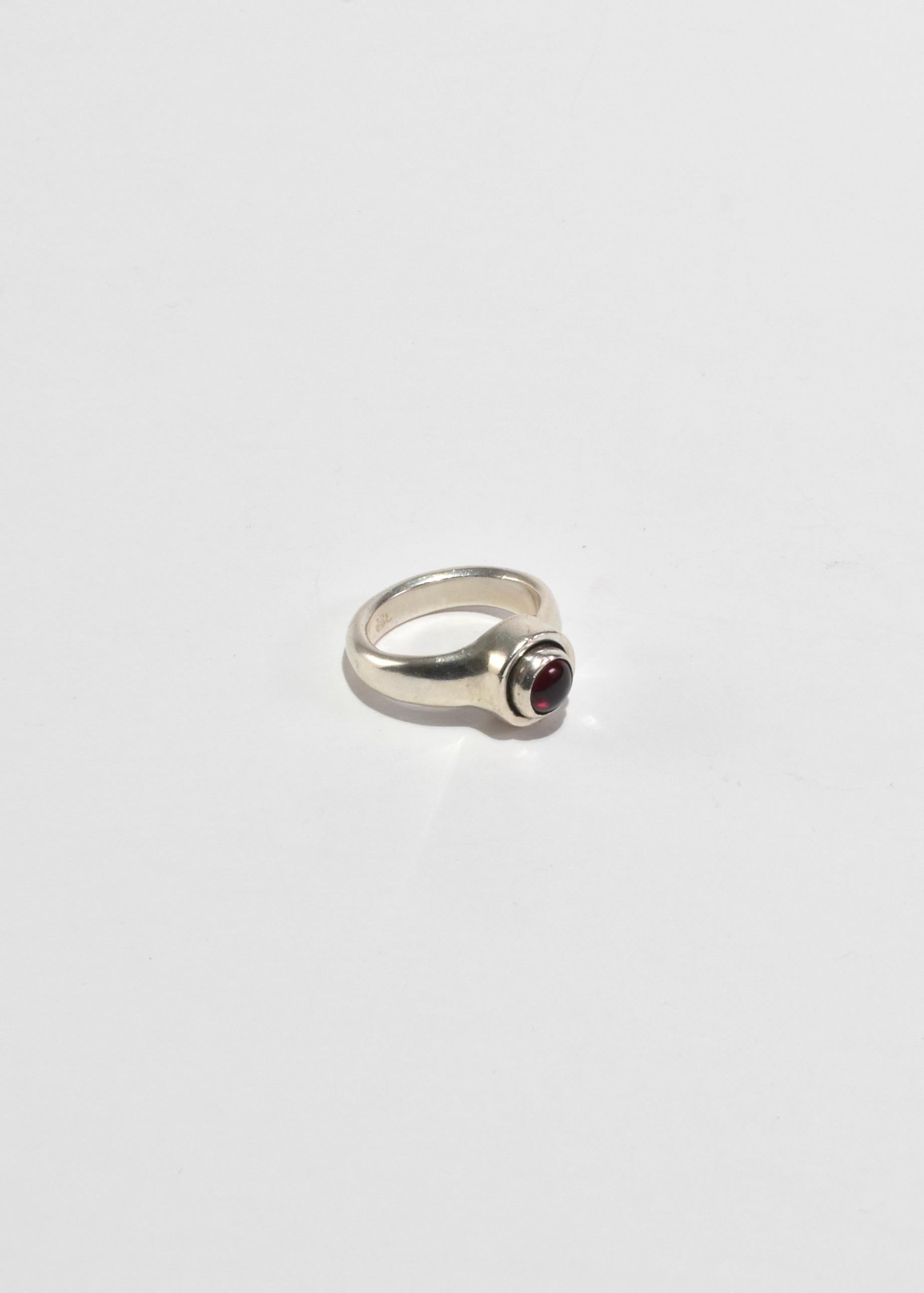Vintage silver ring with a round modernist garnet cabochon. Stamped 925.

Material: Sterling silver, garnet.