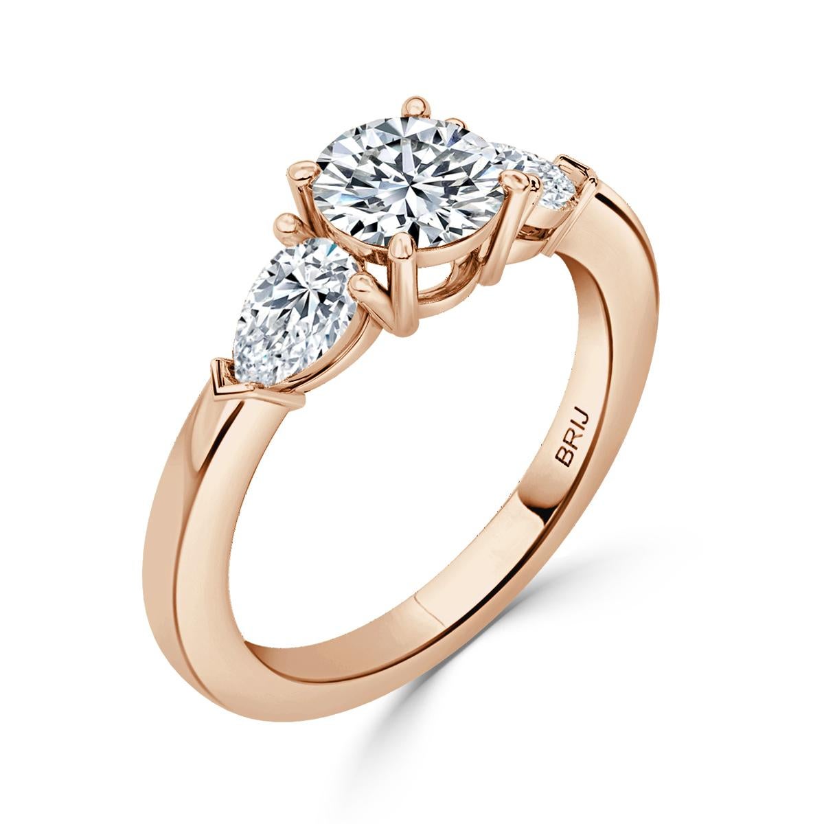 Simple, Classic 3 Stone Diamond engagement ring. Accented with 2 Pear cut GIA Diamonds along the shank  in a 18k Rose Gold setting. 
GIA certified round center stone 0.80 CT
Side Pear Carat weight 0.60 CT

GIA Certified Diamond Details
Weight: 0.80