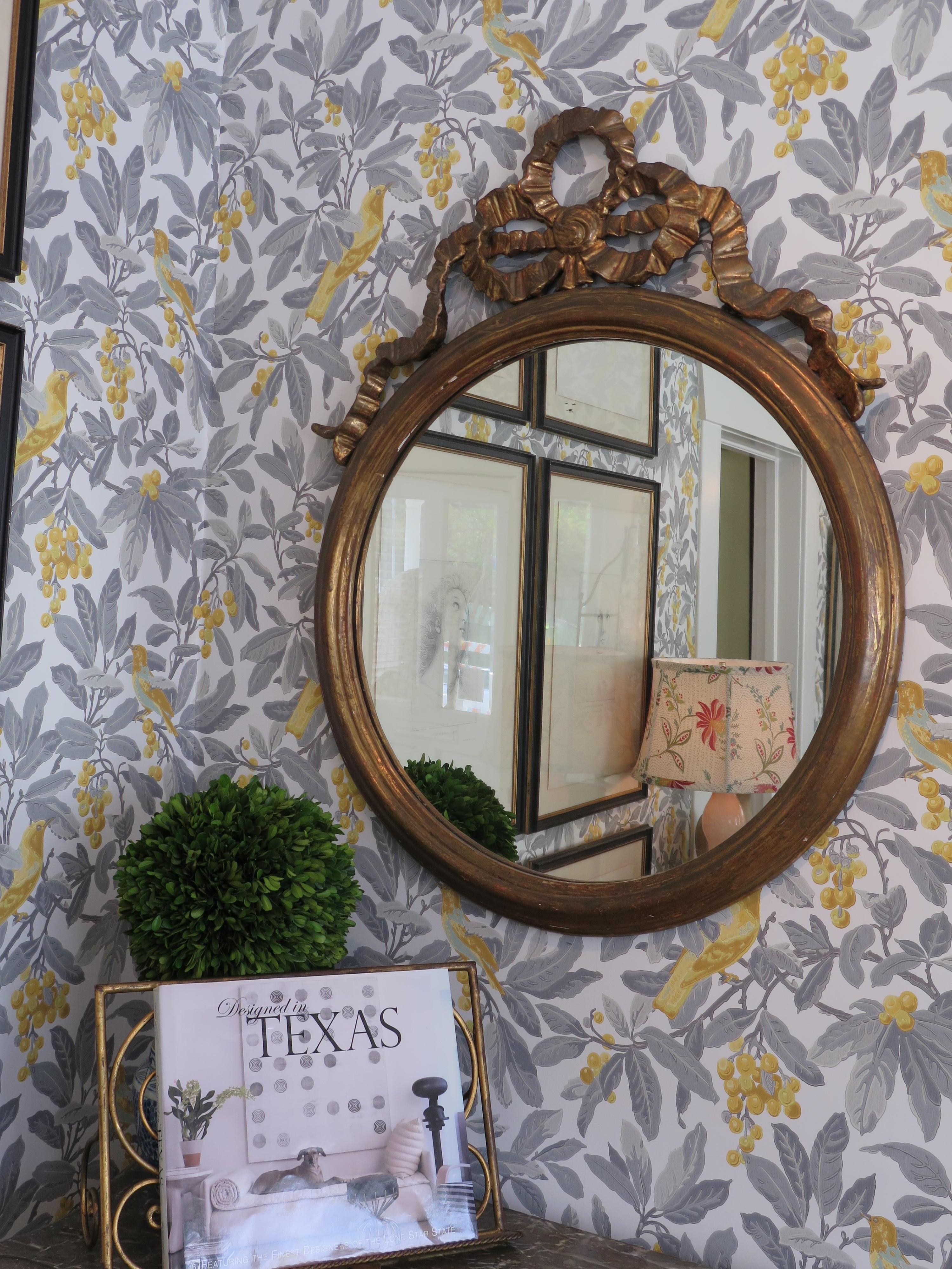 Round gilded mirror adorned with a large bow. Great addition to any space.