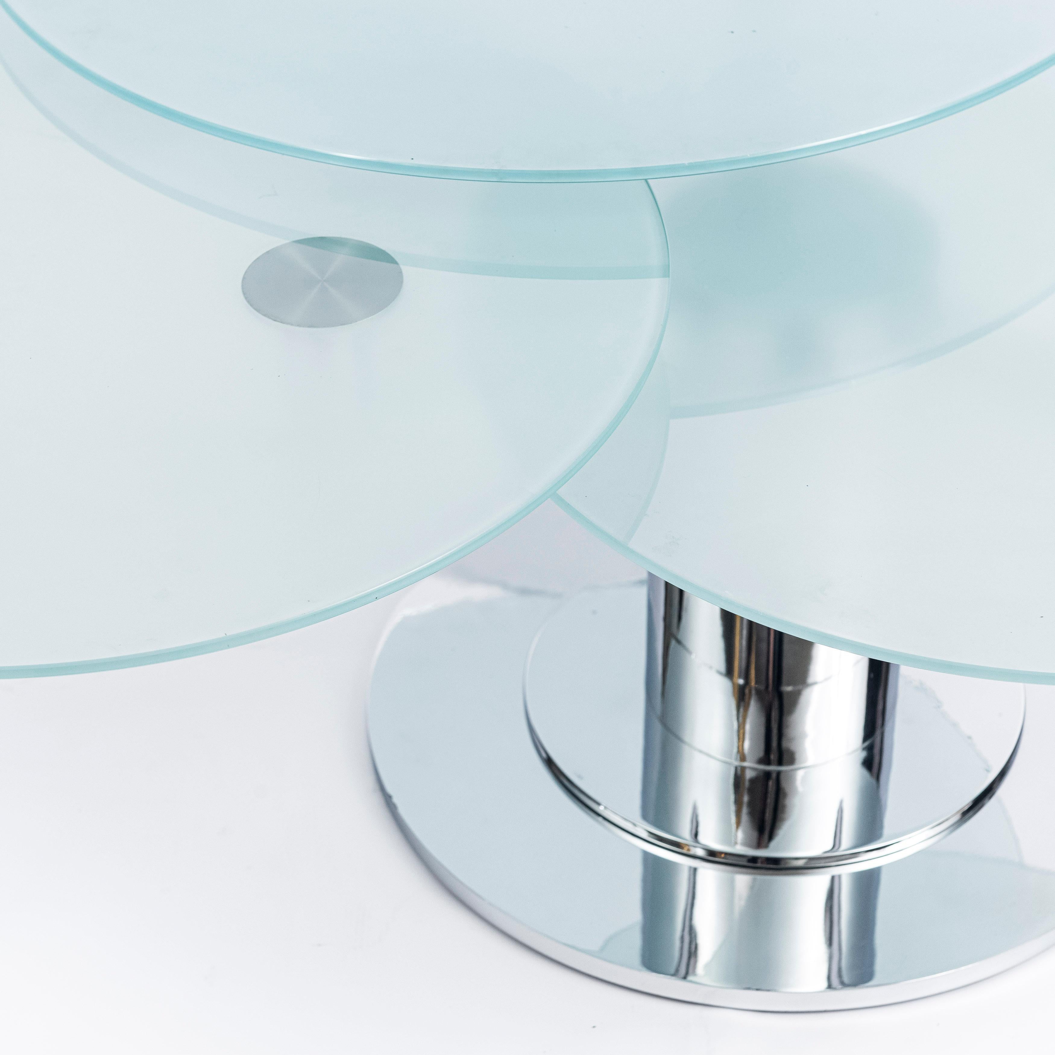 Round glass and chrome metal adjustable coffee table. Italy, circa 1980.

Dimensions open: 135 cm width, 105 cm depth, 45 cm height.
Dimensions close: 100 cm width, 95 cm depth, 45 cm height.