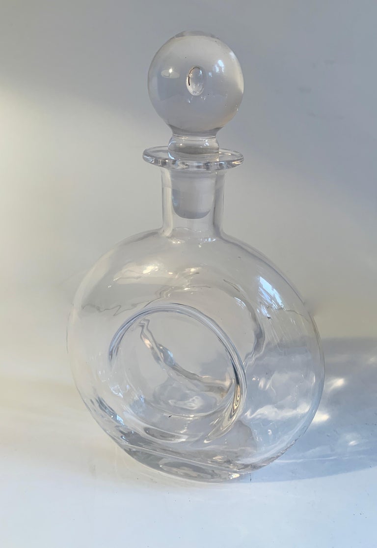 Round glass decanter with crystal stopper.