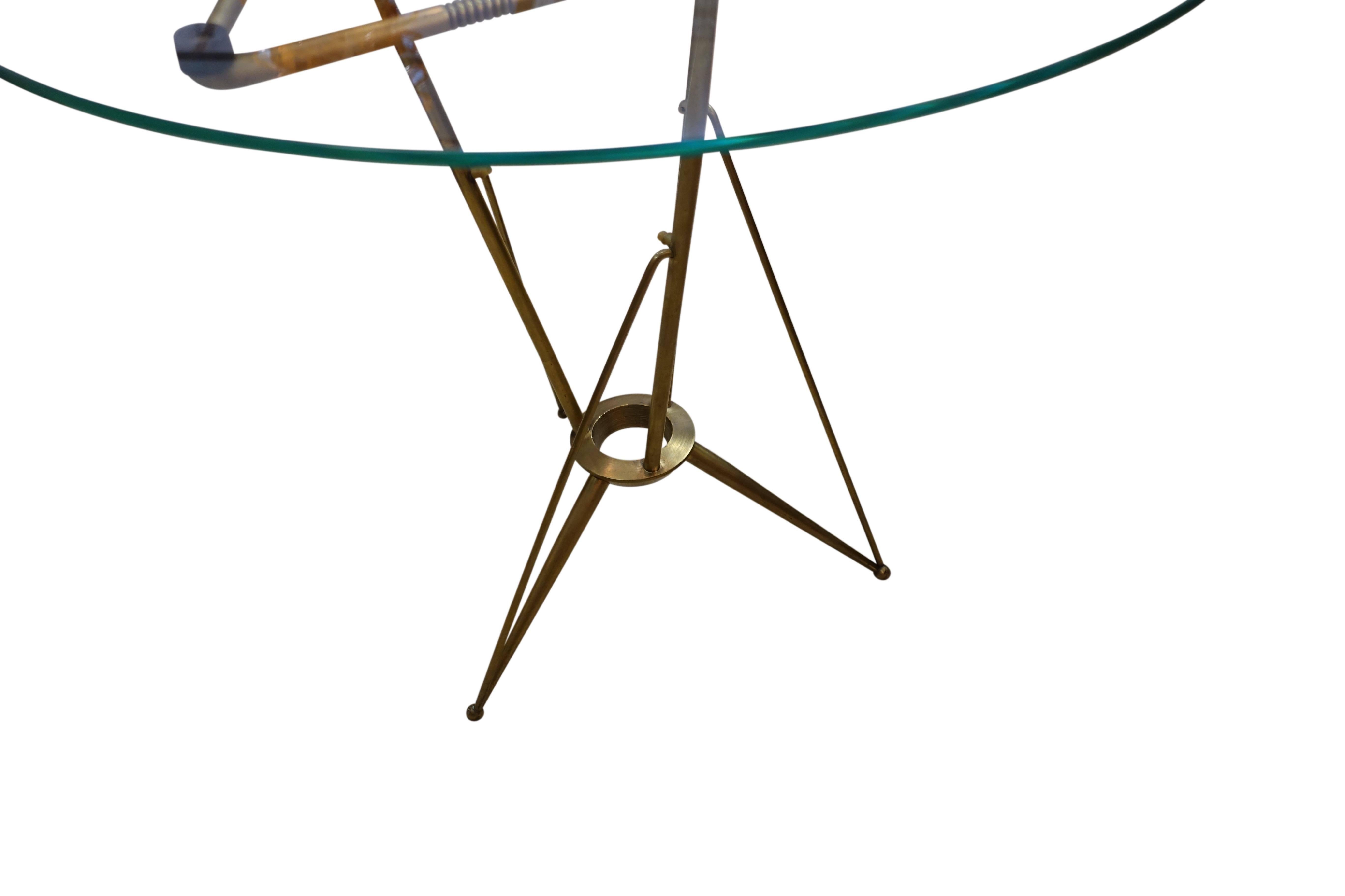 1970s Italian round glass top with brushed bronze criss cross base cocktail table.
Tripod legs have black rubber supports and thin black line details.
Can also be used as a coffee table.
Excellent condition.
 