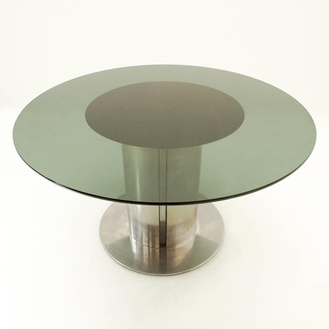 Table with circular top produced by Cidue in the 1970s.
Iridescent steel structure with circular plan with four flares along the leg.
Smoked glass top with slightly bevelled edge.
Good general conditions.

Dimensions: Diameter 129 cm, height 73