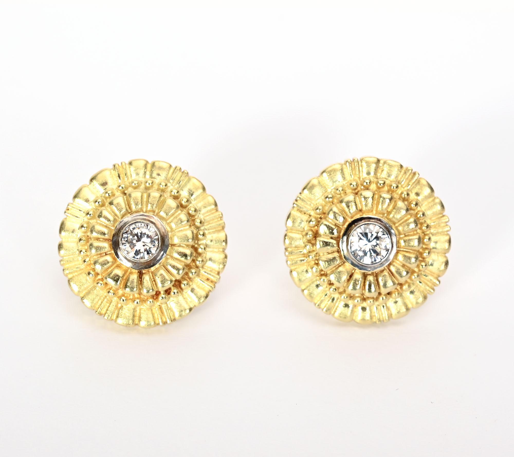 Ces boucles d'oreilles rondes en or présentent un motif en escalier composé de rectangles, de barres et de boules. Ils rayonnent à partir du diamant central d'un demi-carat. 
Les dos sont des poteaux et des clips. La marque du fabricant n'est pas