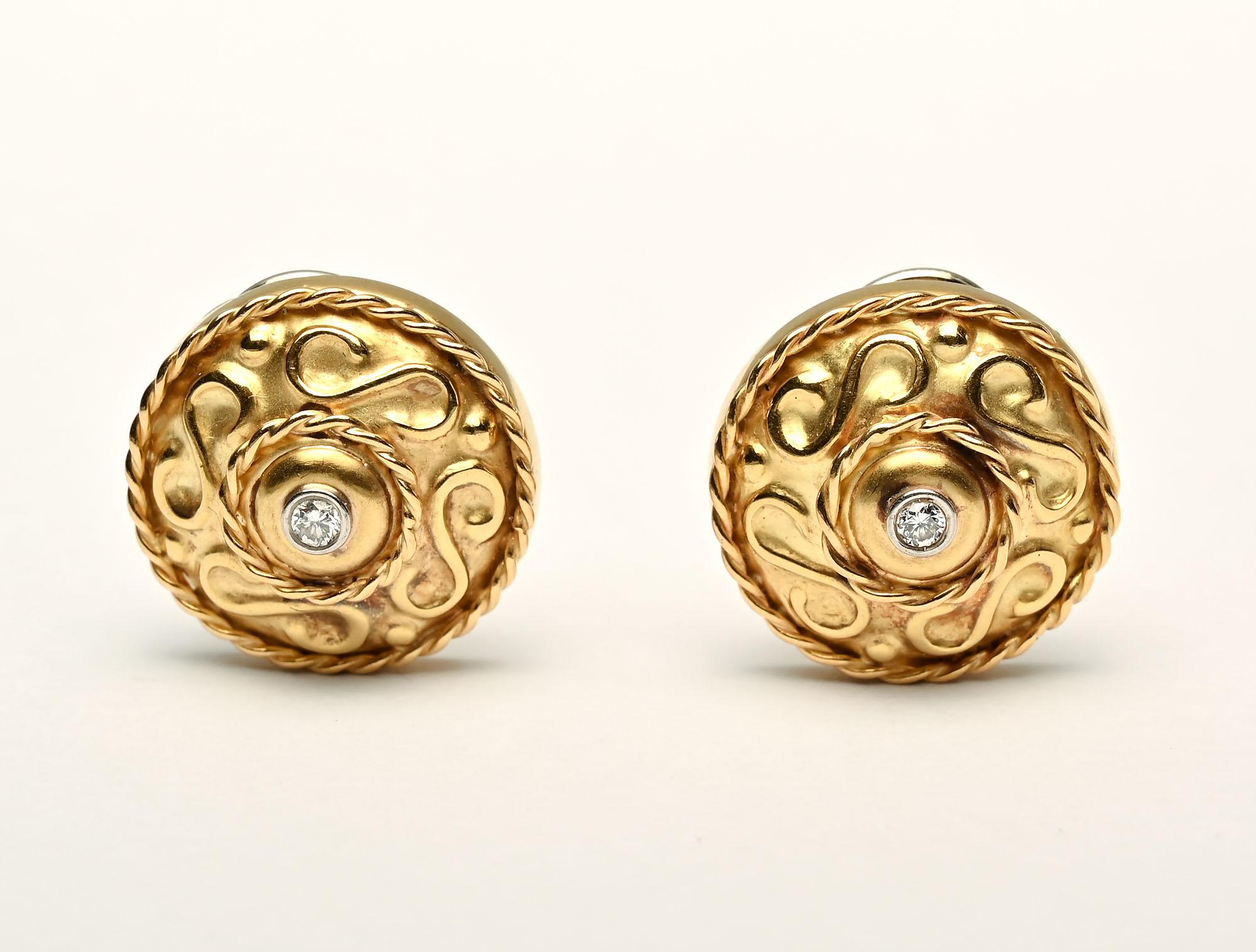 Nicely sculptural 18 karat round earrings, each centered with a diamond. Twisted gold banding around the curvilinear interior design. Signed ANF by the maker. They measure 3/4