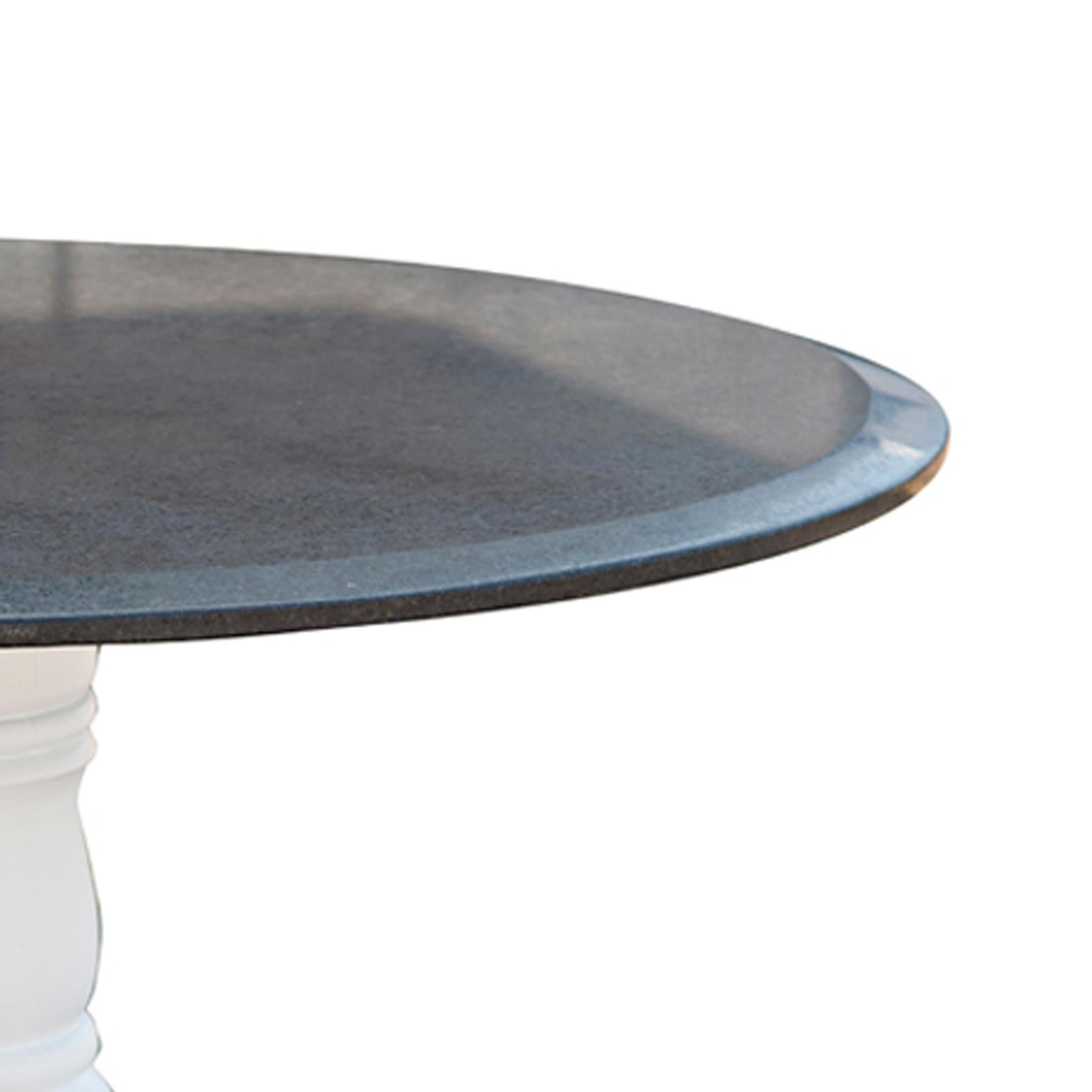 A round dining table with a classic Victorian wooden base and a sleek black granite top.  The base newly lacquered,  The top with a 1.25