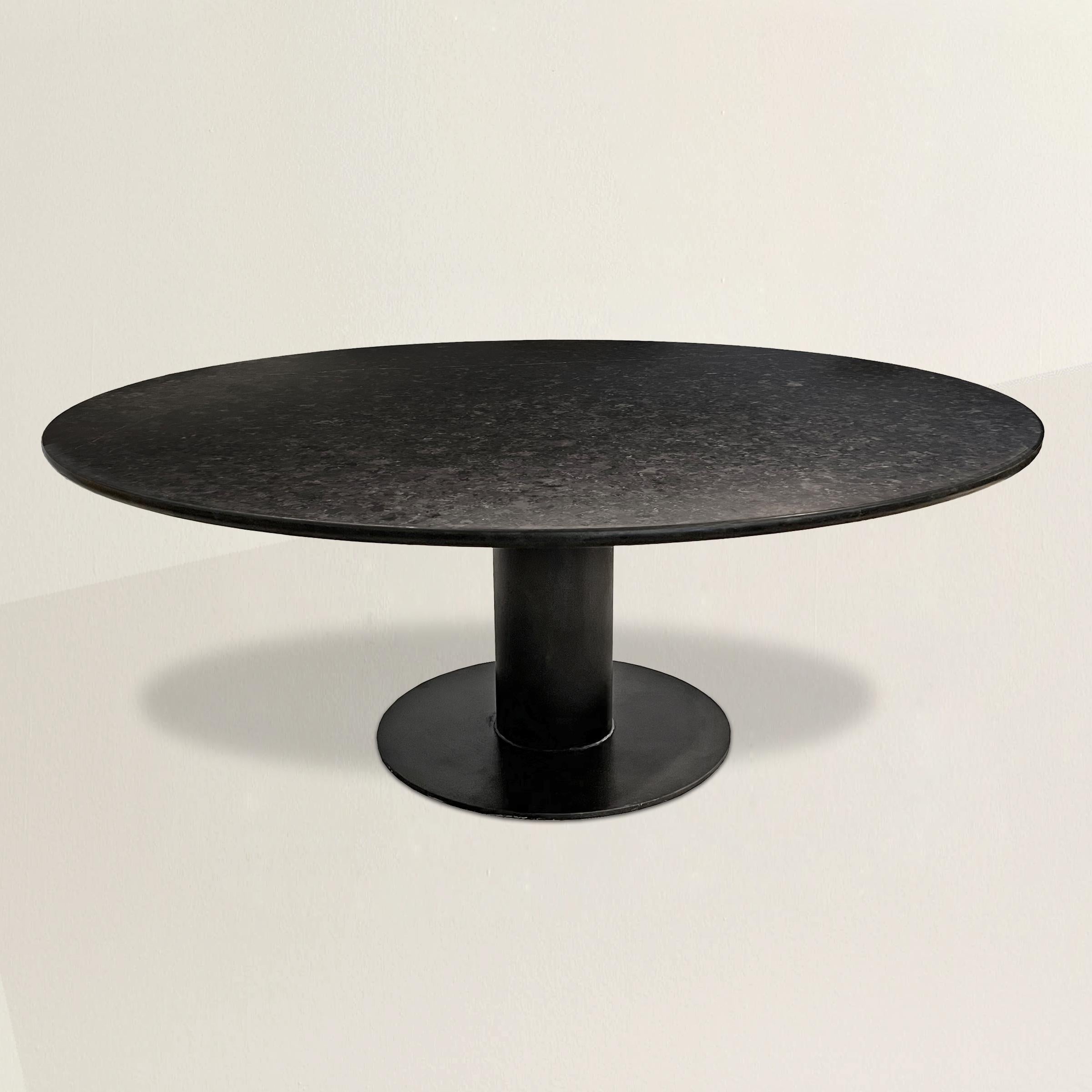 A simple and stunning 21st century round dining table with a custom 6 foot diameter honed Absolute Black granite top with a full bullnose edge detail, and mounted on a found vintage industrial steel base. Easily seats eight people, more at holidays.