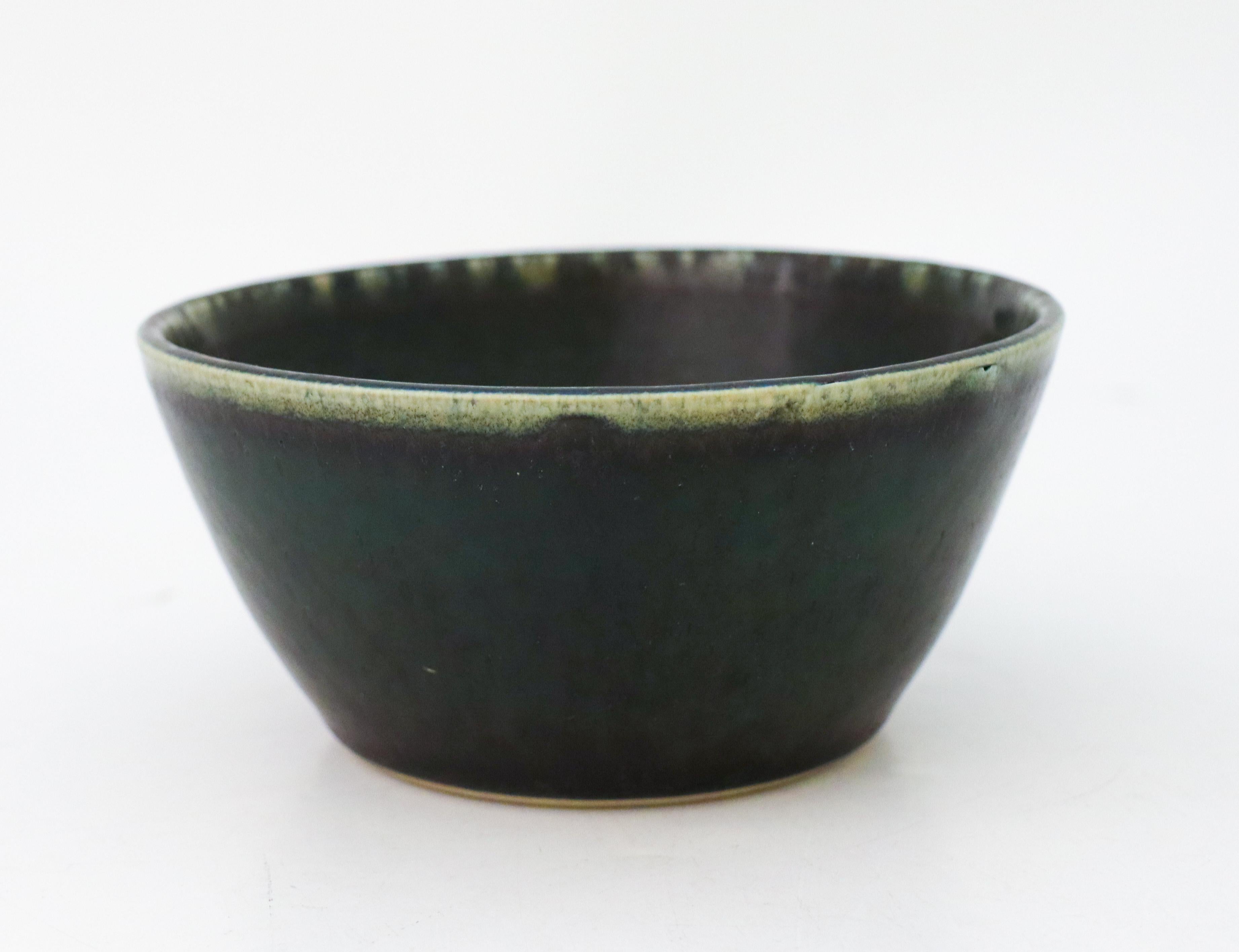 A round, green ceramic bowl designed by Carl-Harry Stålhane at Rörstrand, the bowl is 13,5 cm (5.4