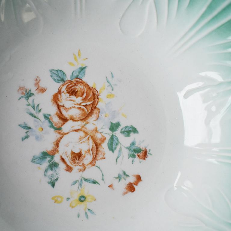 Round green and white cabbage serving dish with floral motif. A lovely way to add a touch of spring to any table! This dish has scalloped edges, with mint green ombre which moves into a cream at the bowl's center. Additionally, around the edges,