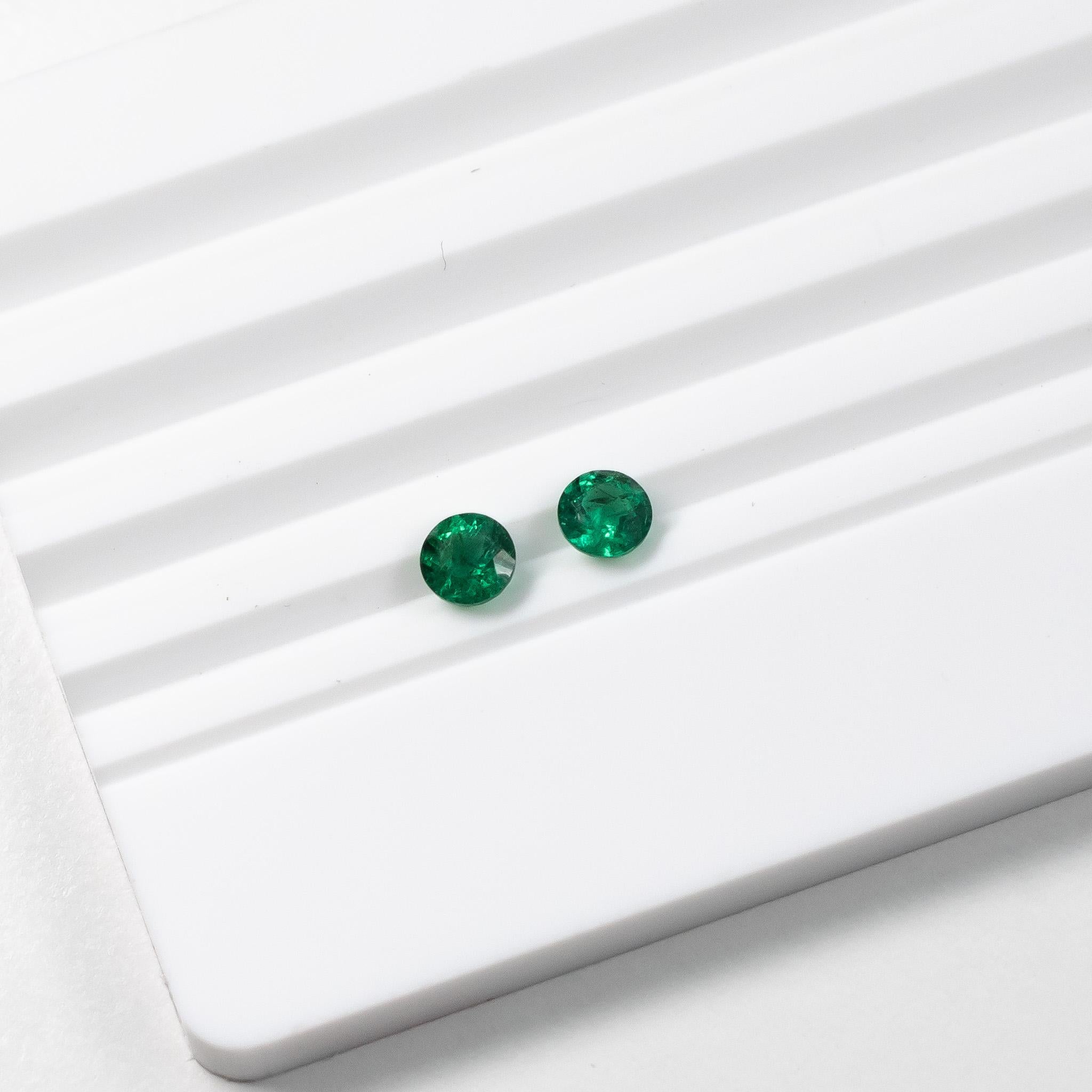 Beautiful round green emerald stud earrings set in Platinum. 

These natural Zambian green emeralds are a stunning vivid green colour. The studs are set in a three prong martini setting with a butterfly push back. 

The emeralds are full of live and
