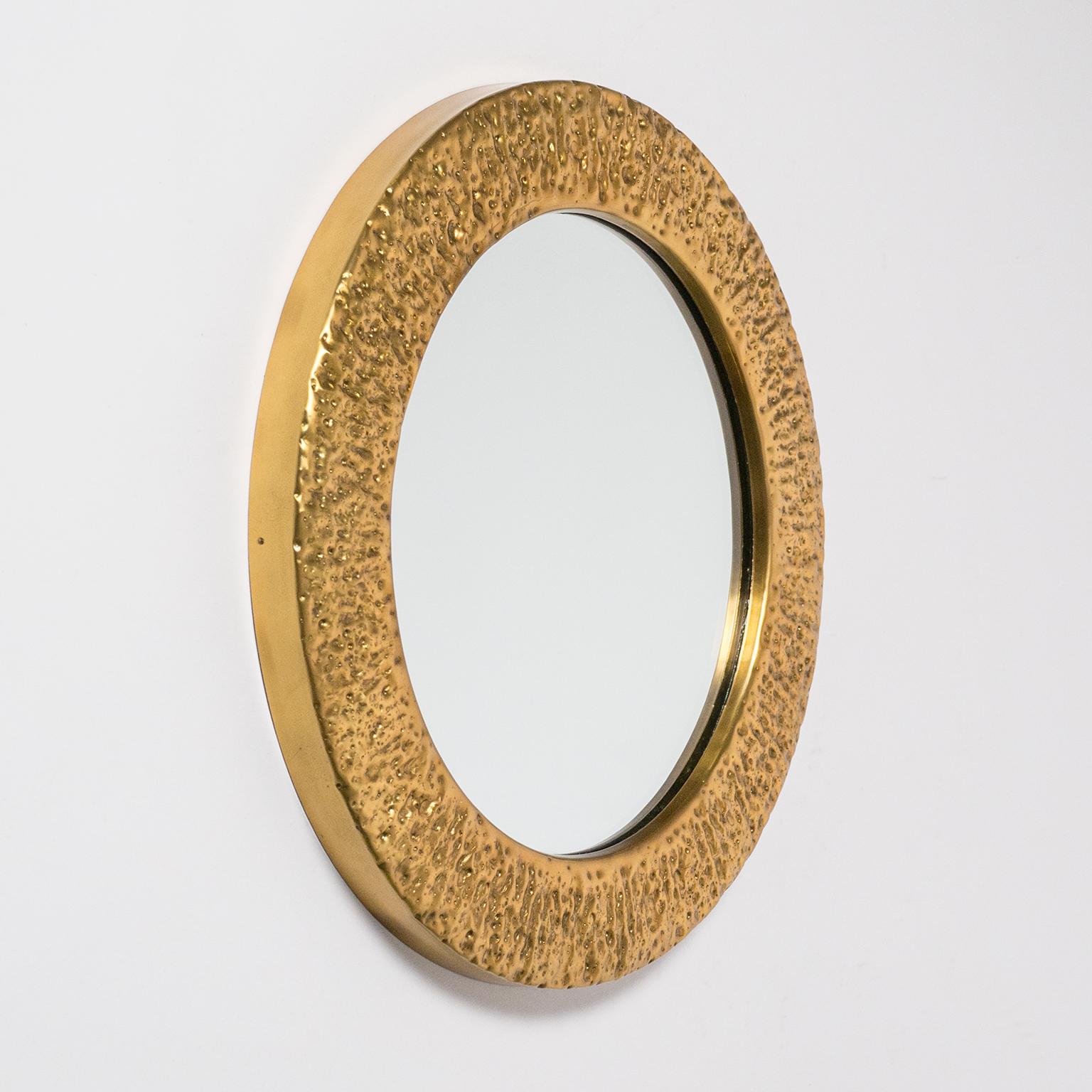 Rare hammered brass (possibly gilt) mirror from Germany, early 1960s. Hand worked, this is a unique piece with a rough and at the same time polished surface. Depending on light conditions and angle the brass frame will change its appearance. Very