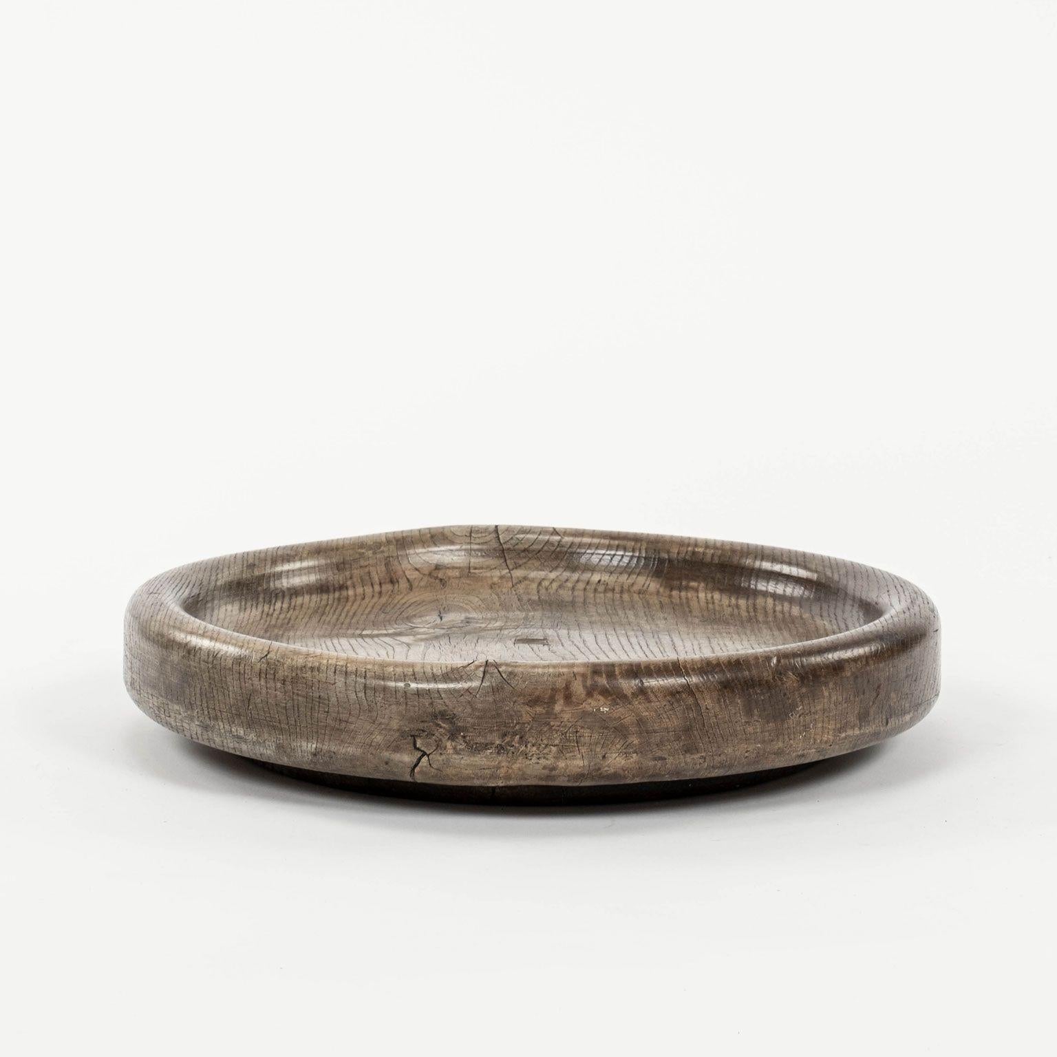Round hand-carved elm cheese platter dating to late 19th century, England. Nice heavy weight and turned footed base.

Note: Due to regional changes in humidity and climate during shipping, antique wood may shrink and/or split along its grain, veneer