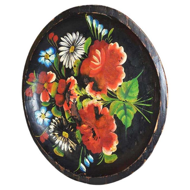 A beautiful round vintage carved wood japanned bowl or dish. Created from Batea wood, this lovely piece comes from the estate of Estelle Thornhill. Deep red and pink hibiscus flowers are hand-painted on a japanned black background. The underside is