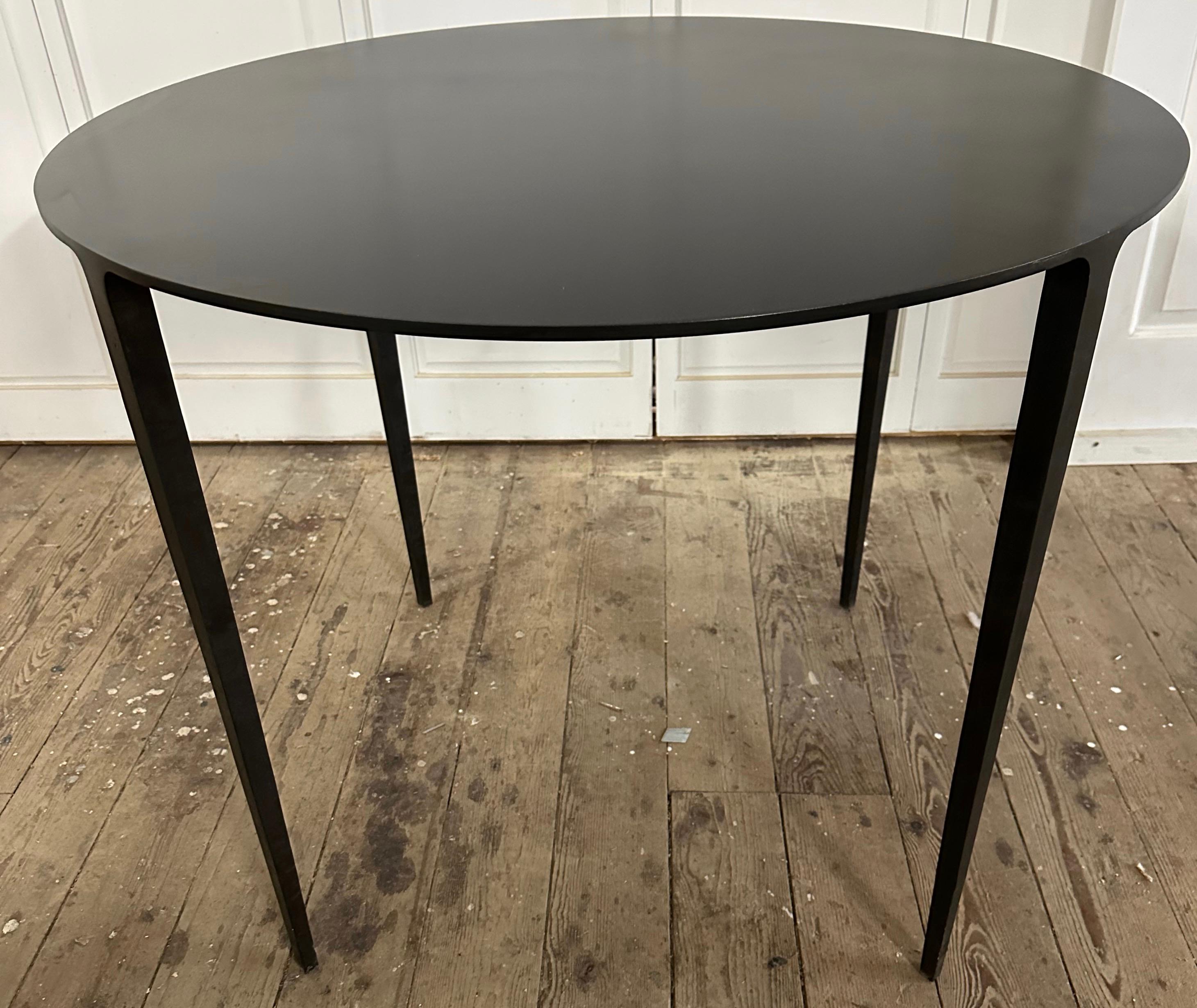 Contemporary minimalist Industrial round blackened steel table is custom hand forged iron.  Use this organic modern table for dining, office or a center table.  The sculpted bottom frame supports a smooth top-surface.
