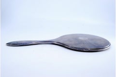 Round hand mirror in smooth silver with sun rays on the back