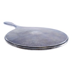 Round hand mirror in smooth silver with sun rays on the back