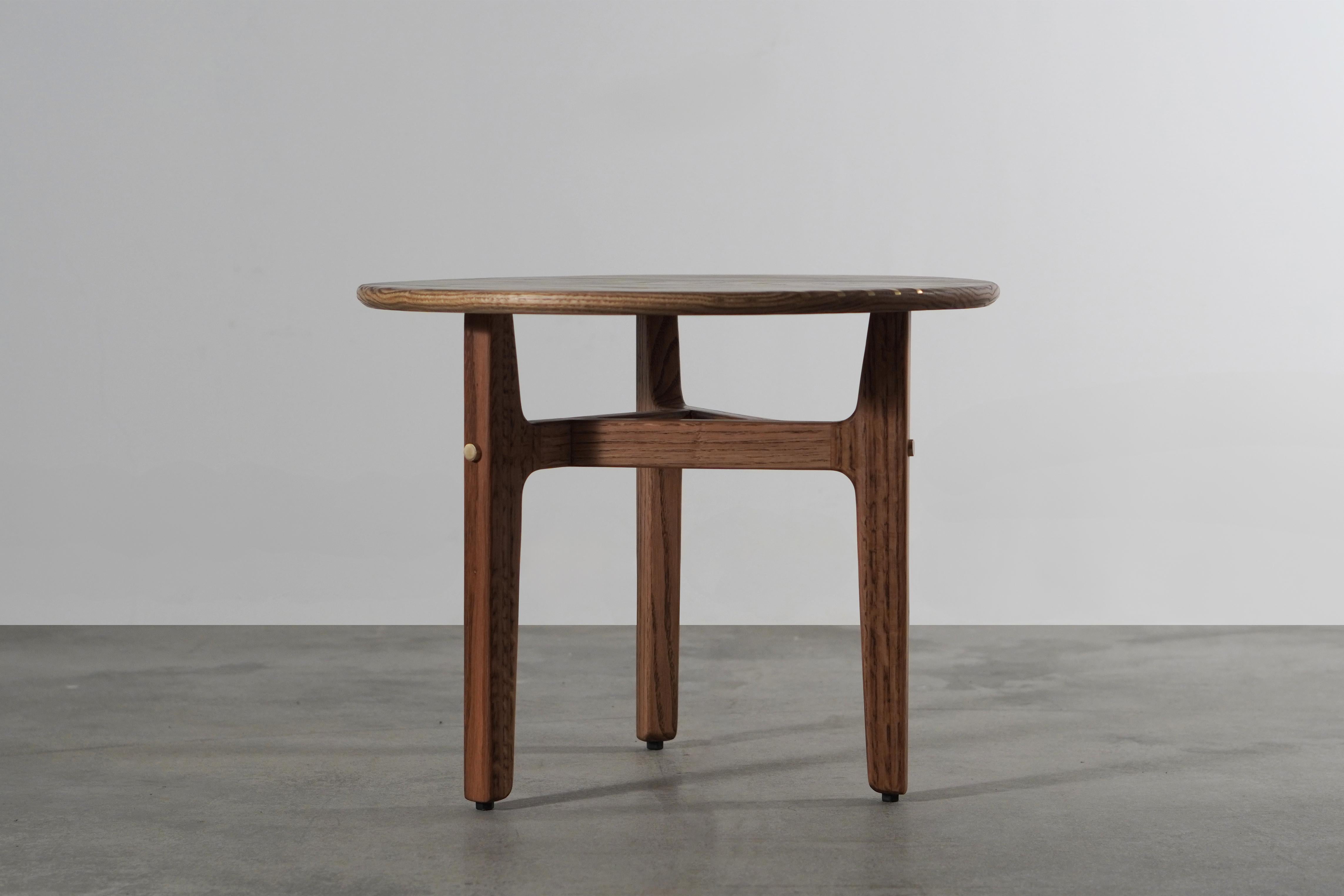 La table d'appoint Comet apporte une touche céleste à votre intérieur. Inspiré par les pluies de météores, son design capture un moment fugace de grâce cosmique. Fabriquée à la main en chêne américain, cette pièce met en valeur la beauté naturelle