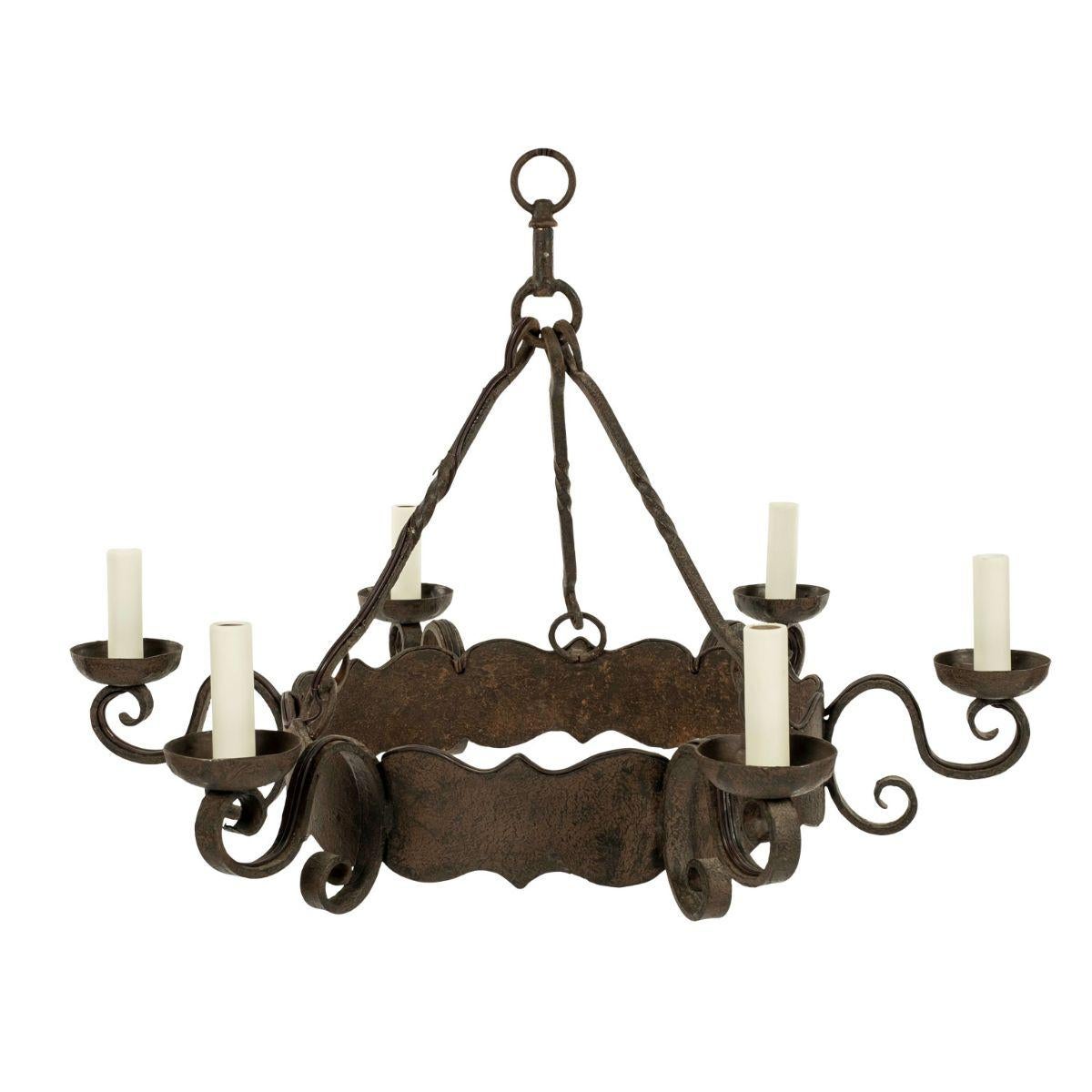 Round heavy iron chandelier dating to the late 19th or early 20th century. Decorative round scalloped band iron chandelier with six scrolled arms. Newly wired for use within the USA using UL listed parts. Includes chain and canopy. Height measured