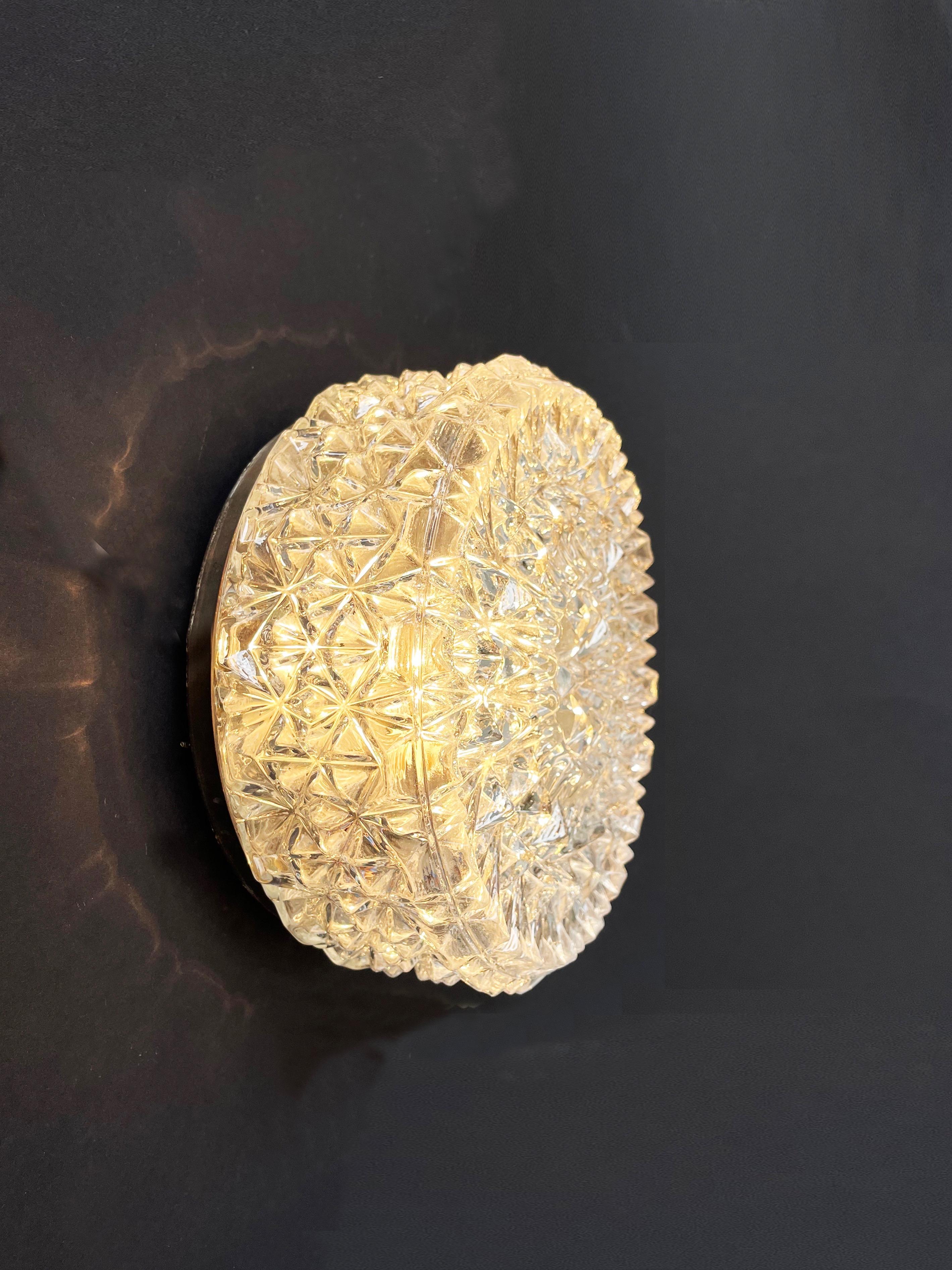 Un'imponente lampada da parete o da soffitto di ERCO Leuchten, Germania. 
Un classico tedesco degli anni '70.
Il paralume è in vetro incolore a forma di cristallo di ghiaccio.
Apparecchio da incasso in metallo con vetro 3D splendidamente