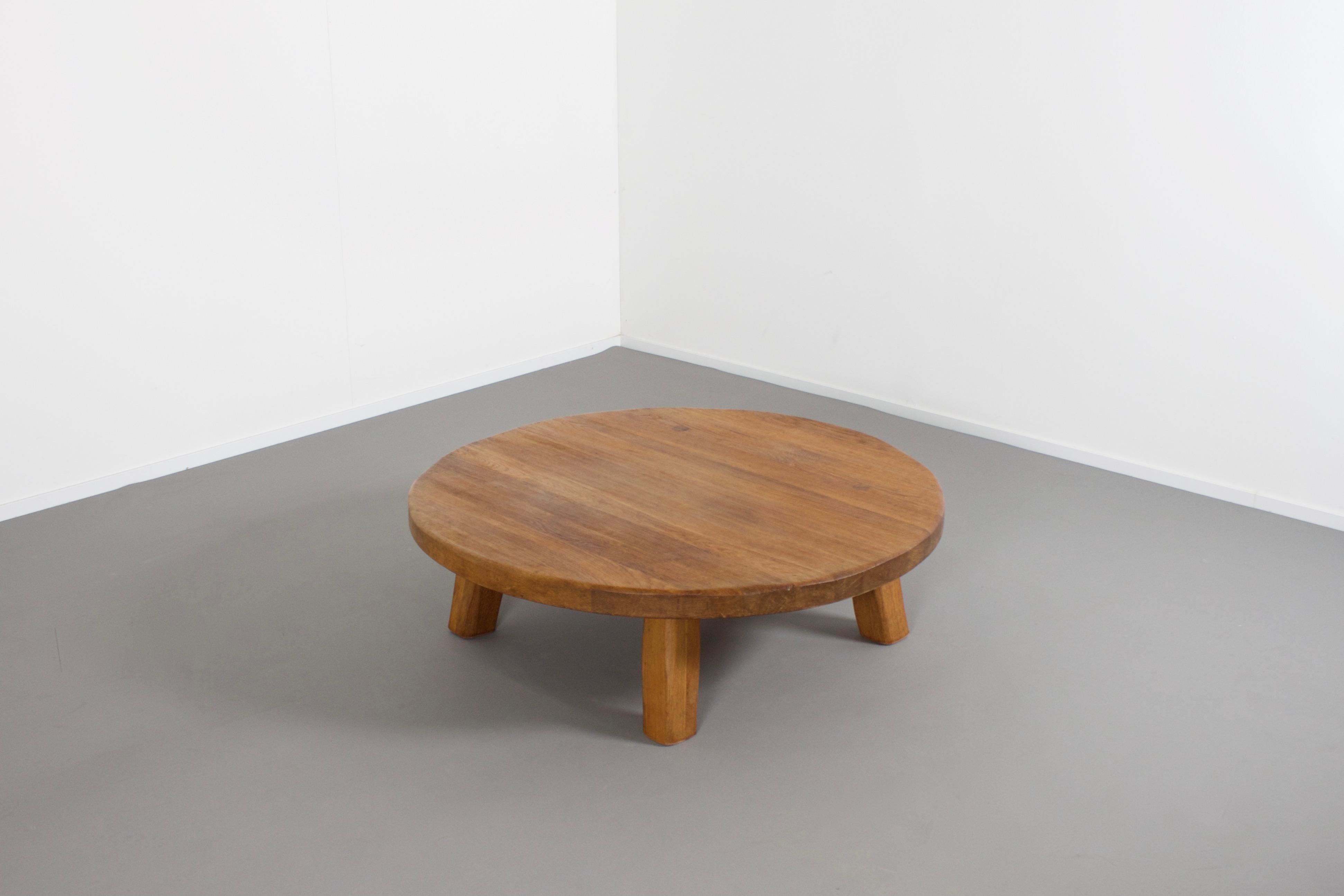Impressive handmade coffee table in very good original condition.

The table is made of solid French oak.

The thick round top is carved which gives it a rustic look it is attached to the base with four visible joints. 

The base is also made of