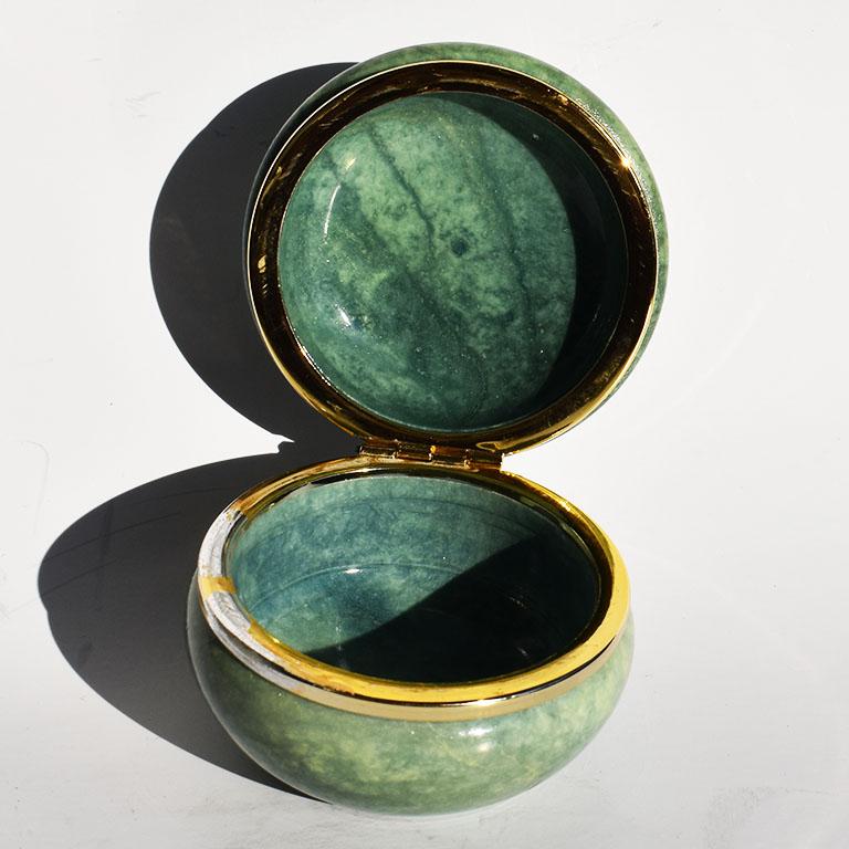 A beautiful midcentury circular round green Italian alabaster hinged trinket box. A soft honed stone storage jar with a lid in a green almost jade or malachite color. The shape is circular with a gold metal hinge and alabaster stone top which opens