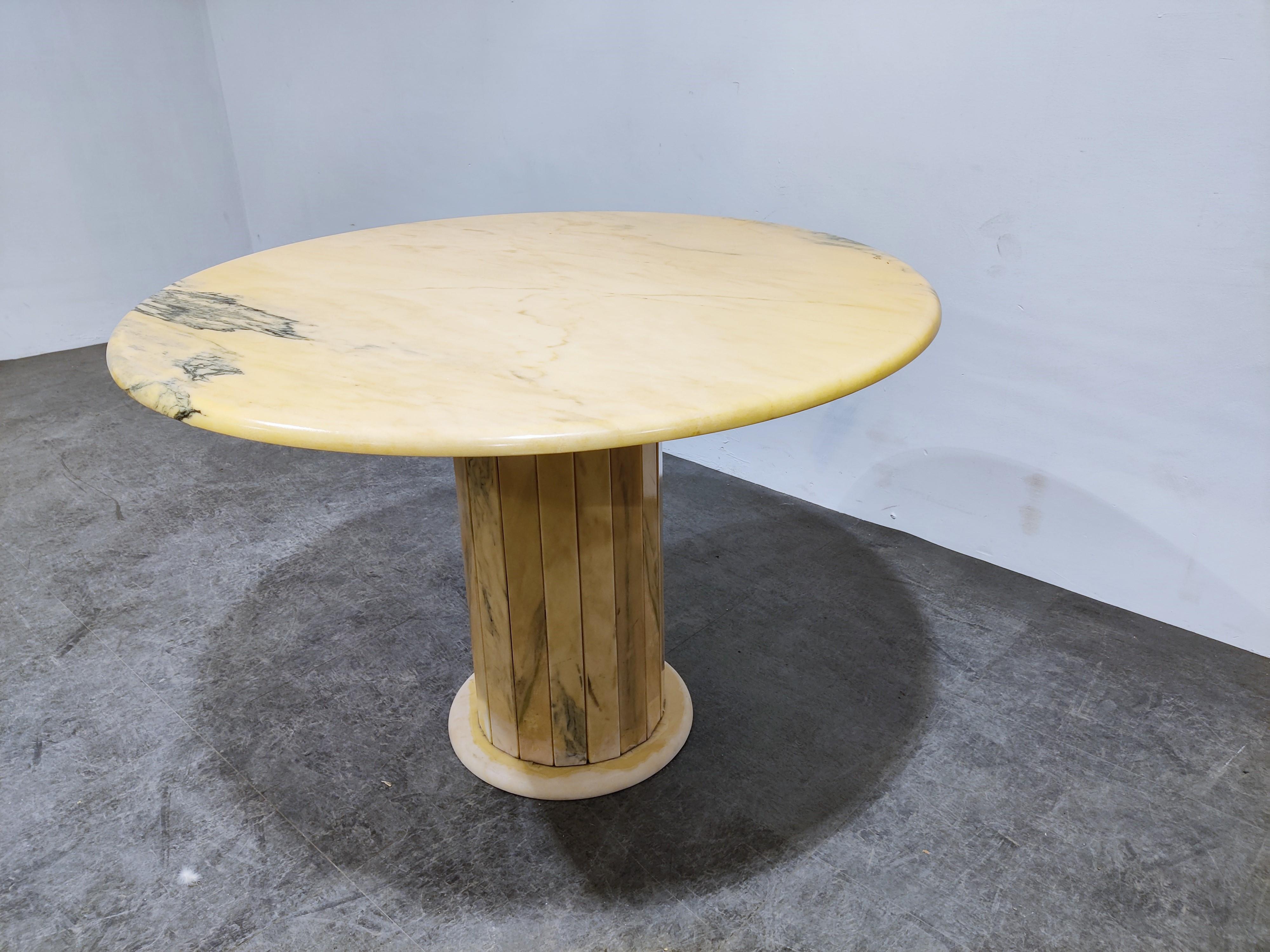 Elegant dining table made from pink/yellow-ish marble

Beautiful natural vaining.

The round top is sitting on cillindrical slatted marble base.

Good condition

1970s - Italy

Measures: Height: 75cm/29.52