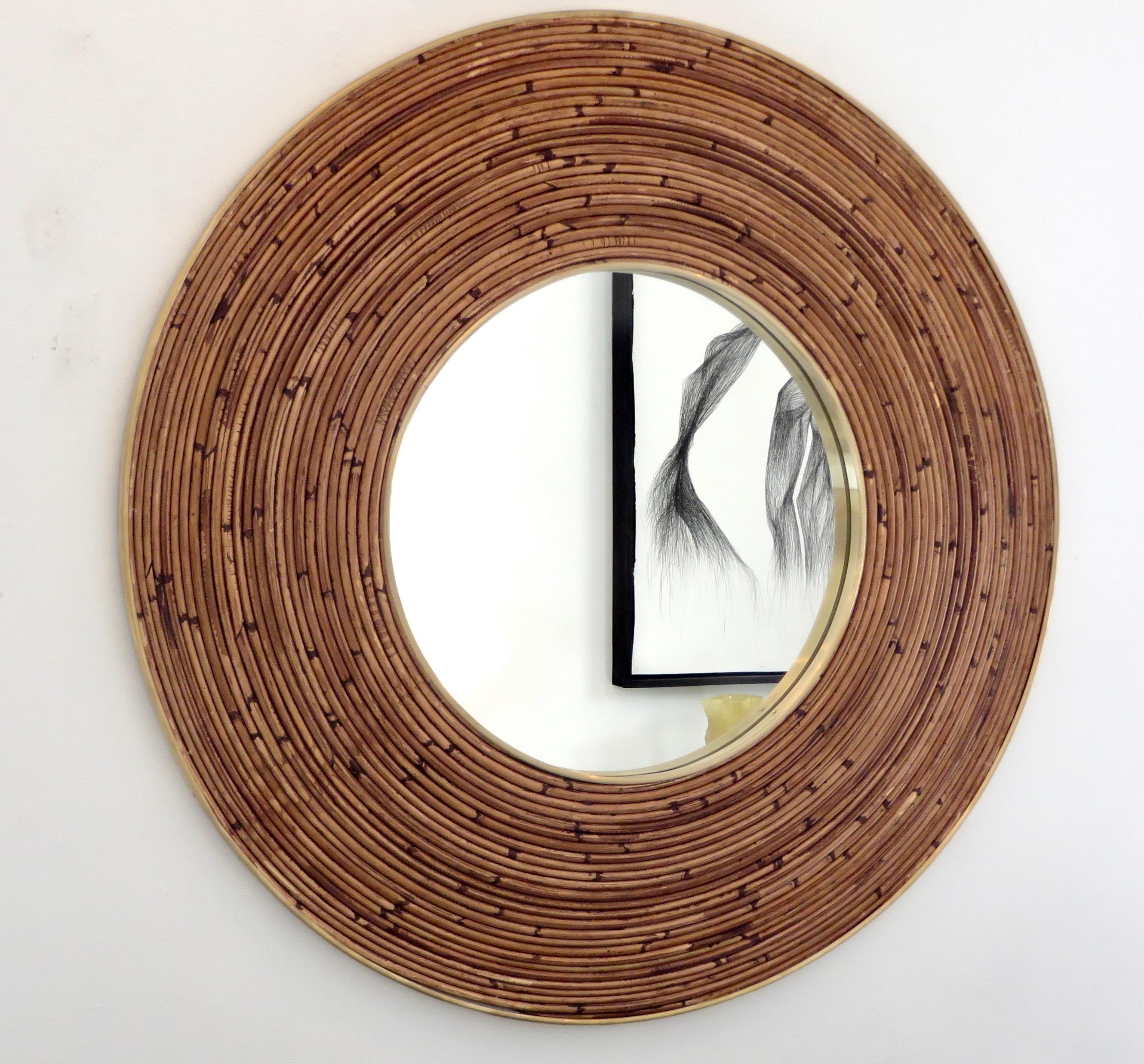 A large Italian round rattan bamboo and brass framed mirror.
There is a brass frame not only on the outside but surrounding the mirror portion itself.
Excellent condition with no breaks or losses to the rattan.
Variegated coloration is in the rattan