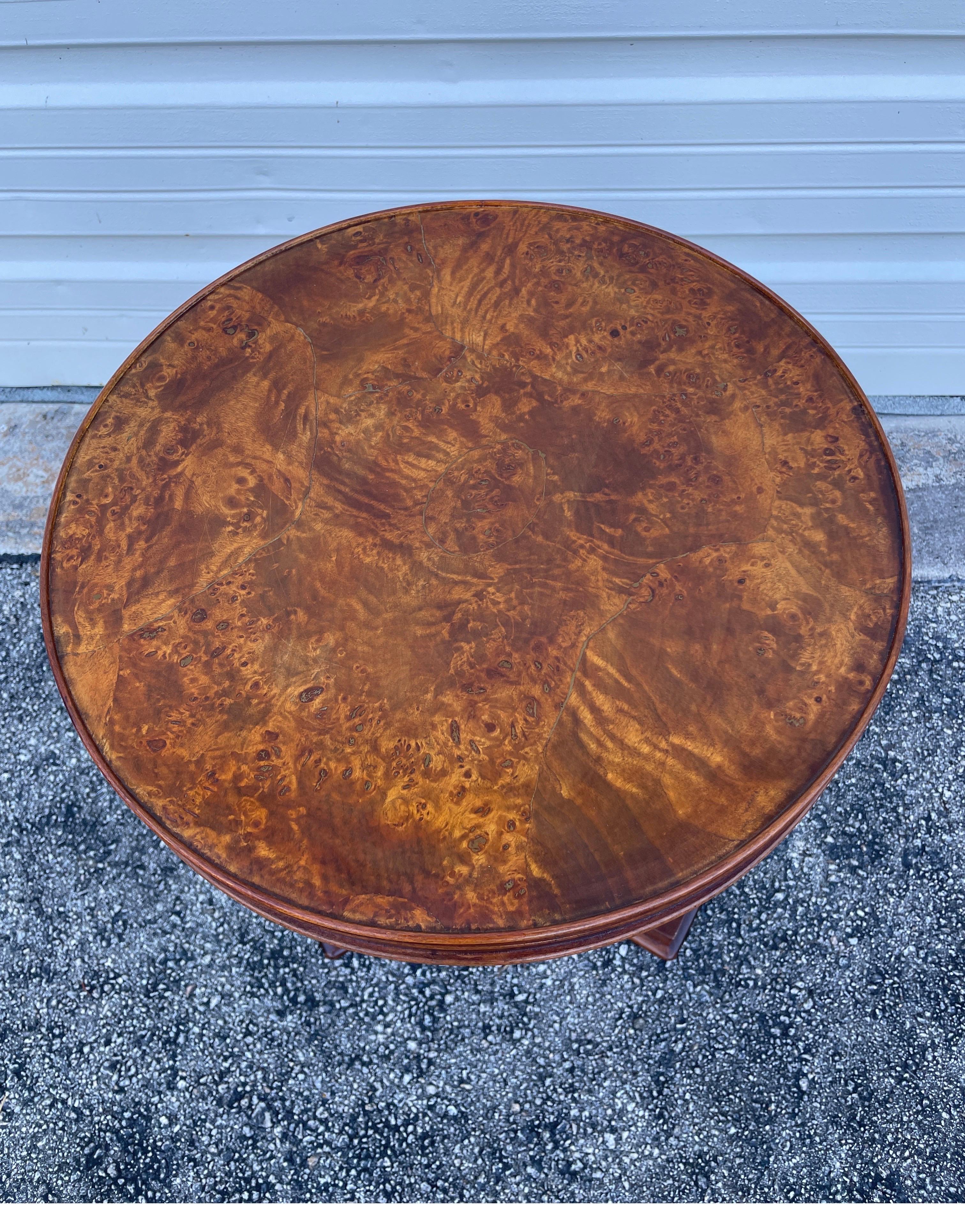 Round Burlwood top Italian tripod table. Top is supported by three swan head legs attached to base.