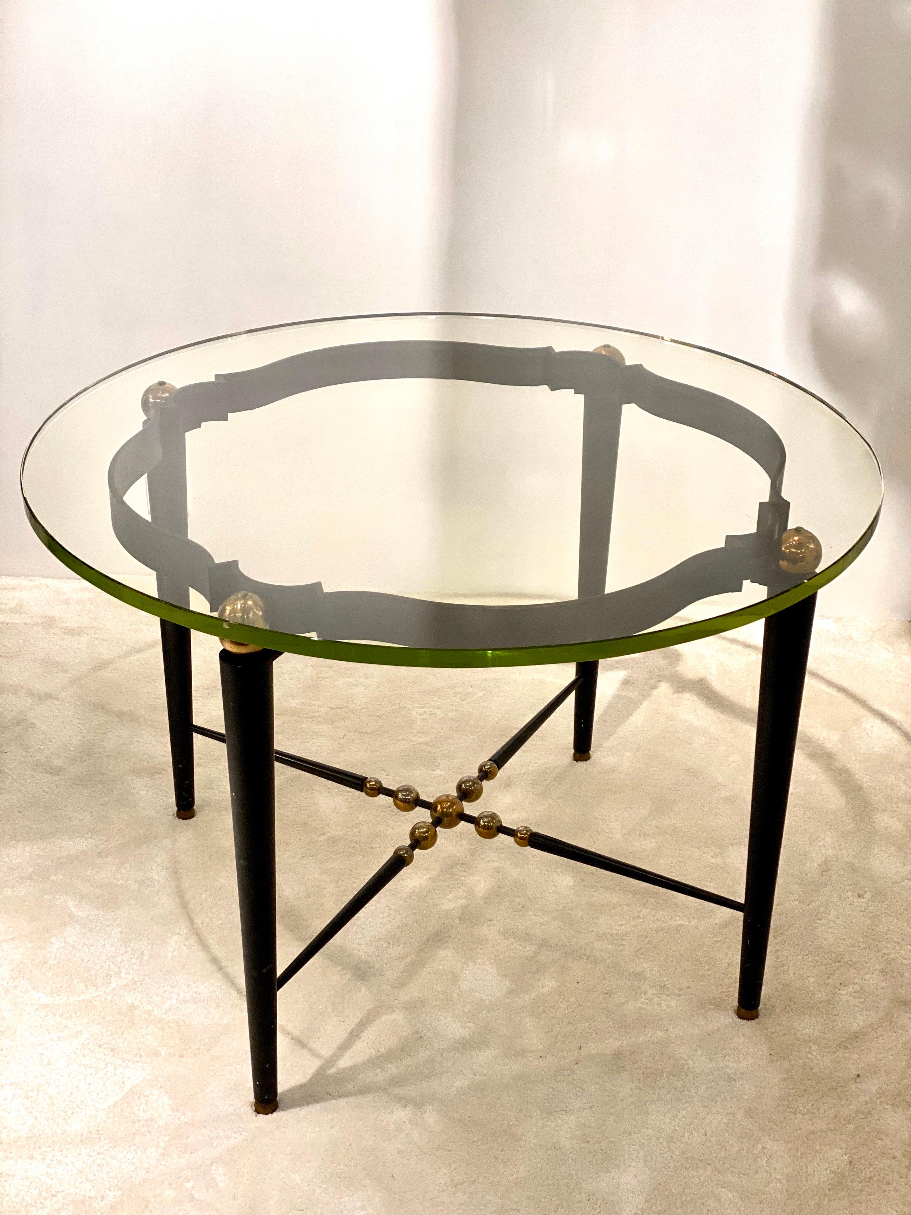 An elegant round Italian table made off wrought iron (base and legs), gold brass spheres and a thick Saint Gobain glass .
1940s style with a modern vibe due to the details, unusual, rare, perfect for Deco!