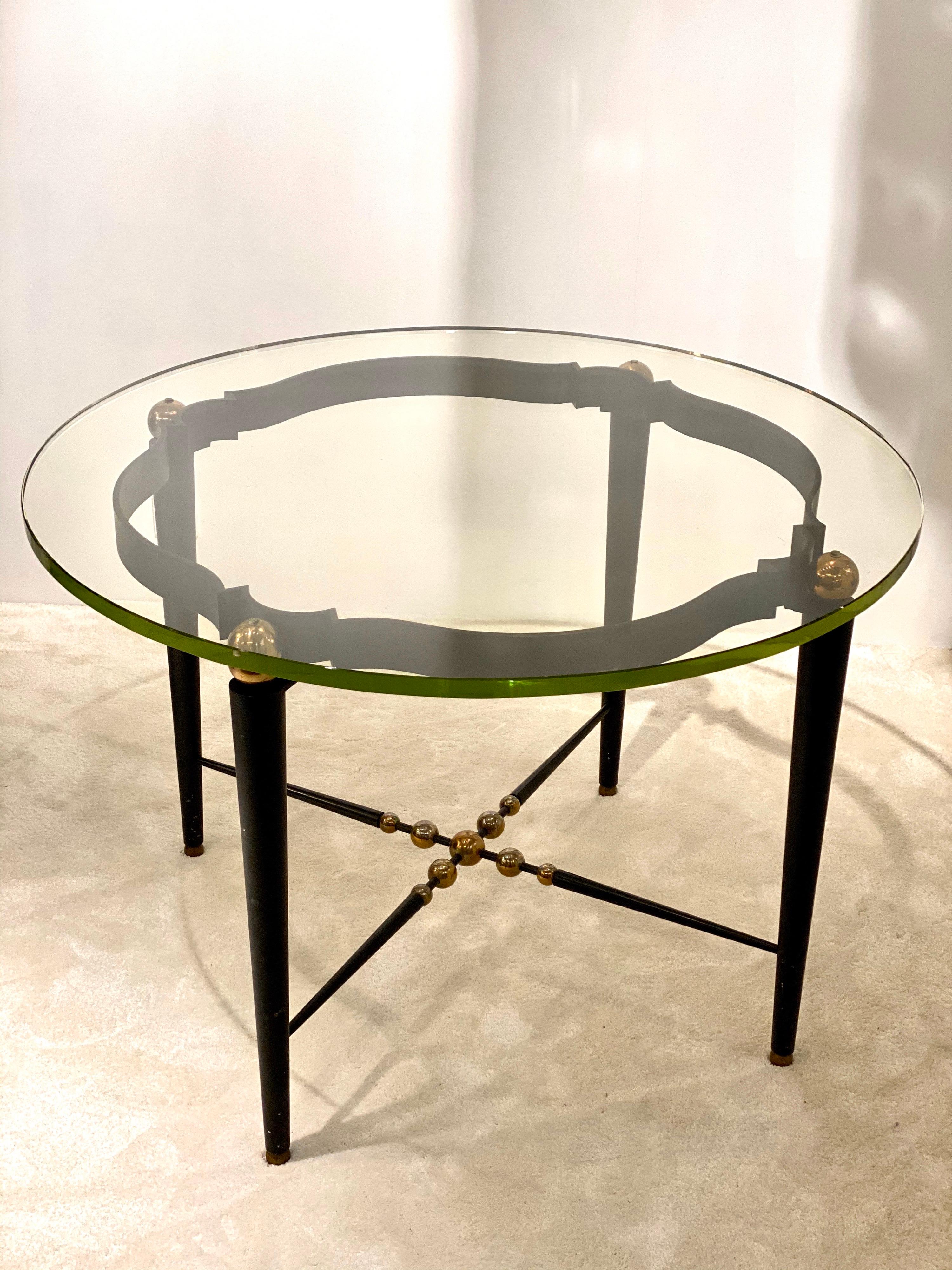 Un elegante tavolo rotondo italiano realizzato in ferro battuto (base e gambe), sfere in ottone dorato e uno spesso vetro di Saint Gobain.
Stile anni '40 con un'atmosfera moderna grazie ai dettagli, insolito, raro, perfetto per il Deco!