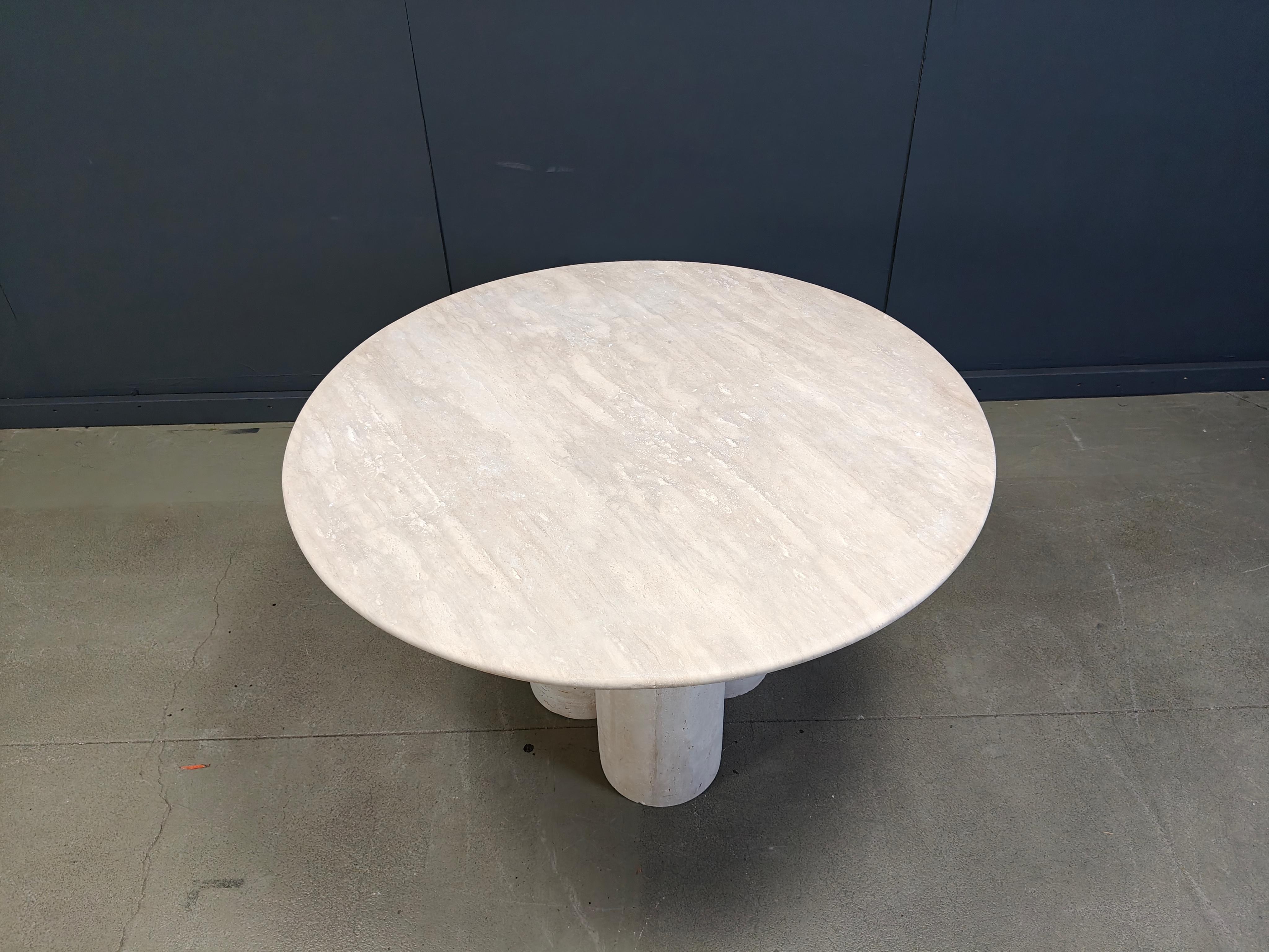 Bellissimo tavolo da pranzo in travertino con tre grandi gambe centrali a forma di cilindro.

Pietra di travertino naturale di bell'aspetto. 

Piano rotondo ben rifinito.

Buono stato

anni '70 - Italia

Altezza: 74cm/29.13