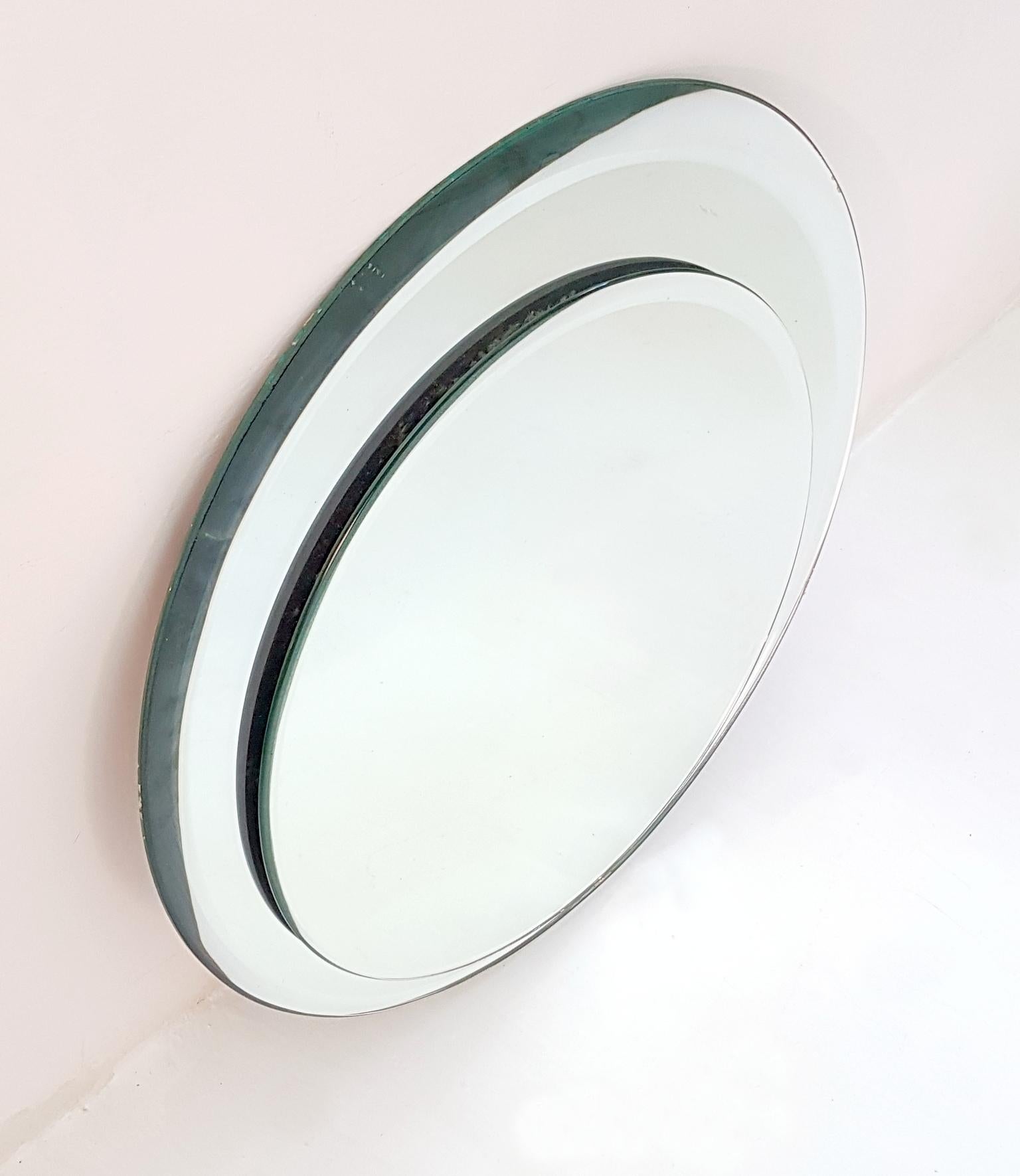 An Italian round vintage mirror with a double mirror glass circle design.