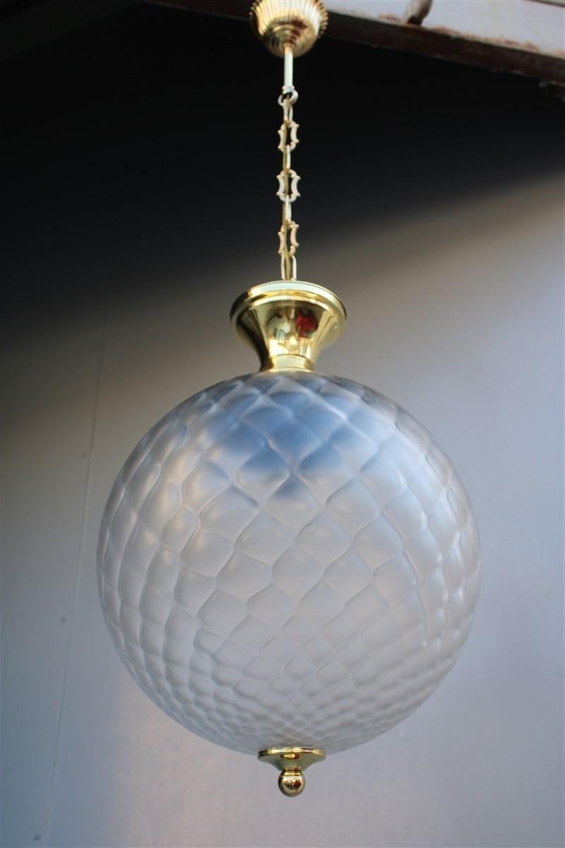 Elegant and classy this Italian lantern of about 1950s, made with a Murano glass bubble in mesh and the structure in brushed brass and has been polished.
