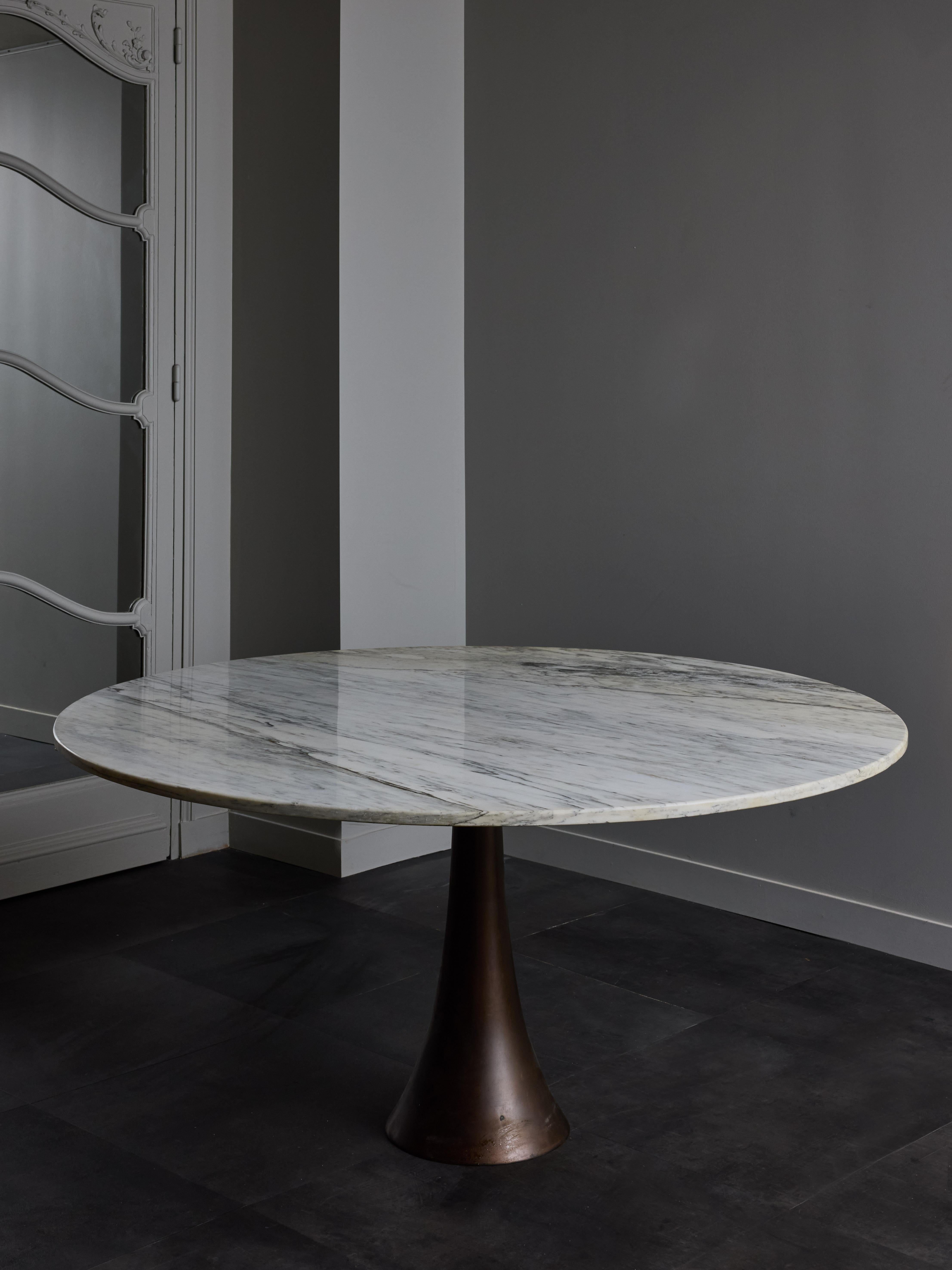 Large round gueridon, which can be used as a dining table for six people, made of a trumpet shaped metal foot supporting a a carrara marble top