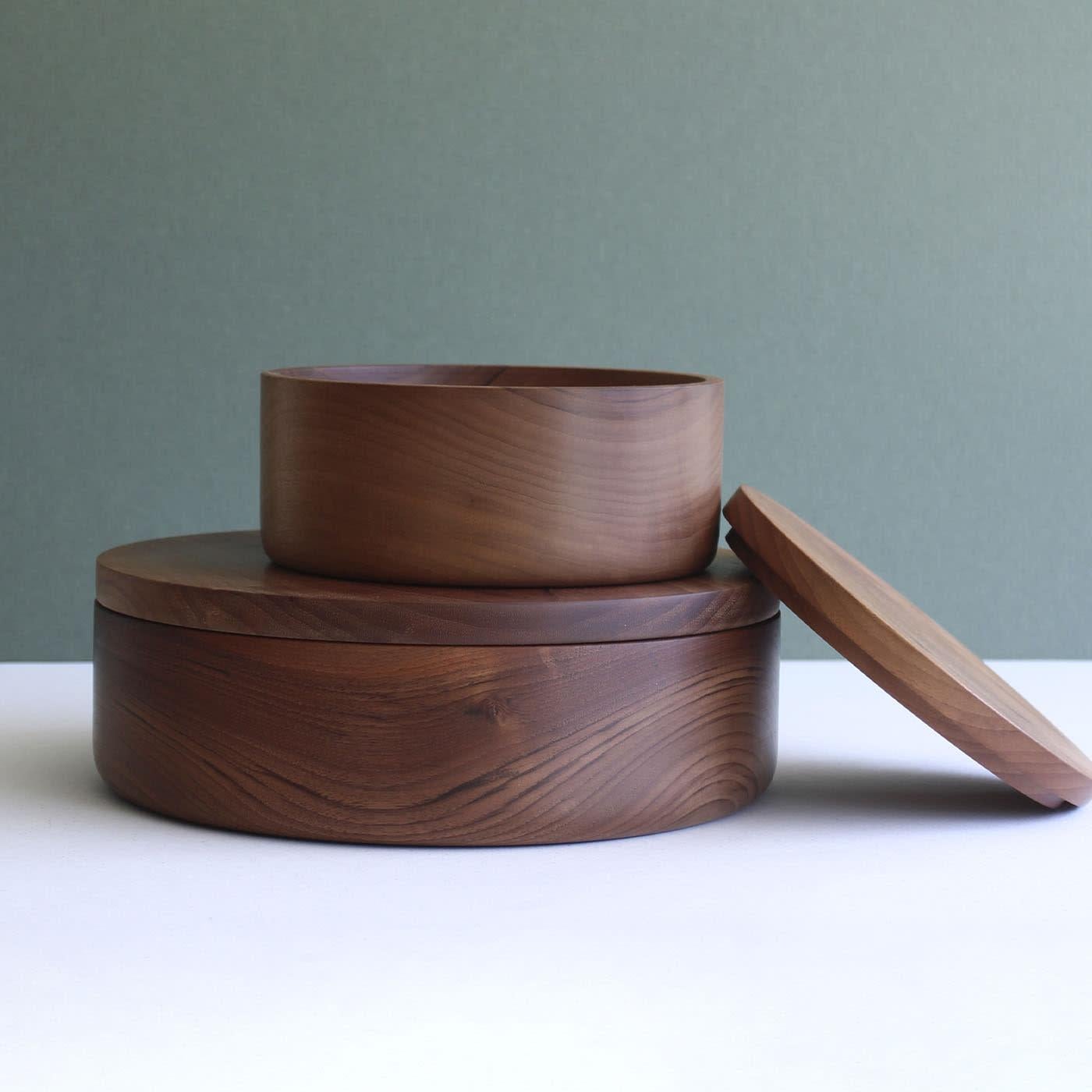 Diese handgefertigte zylindrische Schachtel aus massivem Nussbaumholz ist ein idealer Aufbewahrungsort für kleine Tortillas und verfügt über einen flachen Deckel, der die minimalistische Silhouette und die schlichte Eleganz der Schachtel