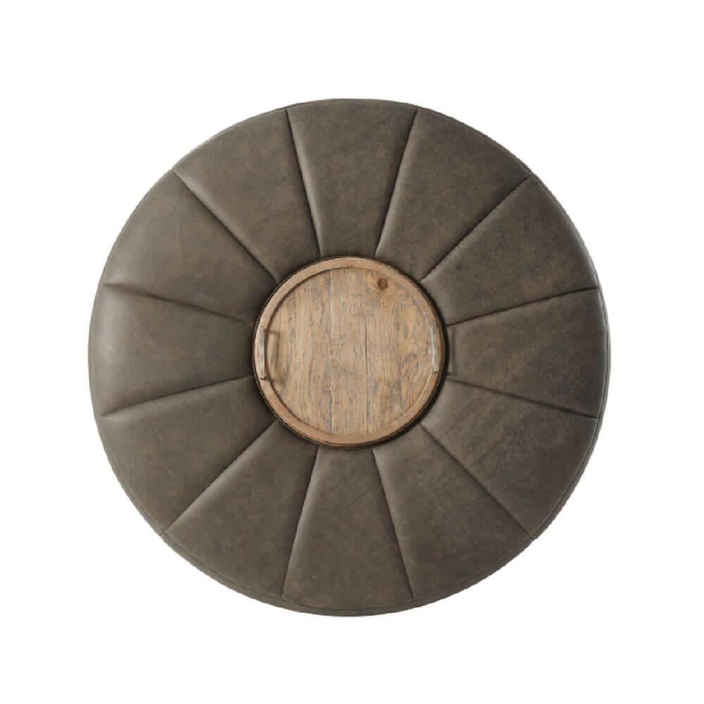 A modern leather upholstered round ottoman with a starburst channeled seat, centered by a removable dish top tray with textured vintage metal handles on an oak bae with square tapered legs in a light oak finish.

Dimensions: 45.25