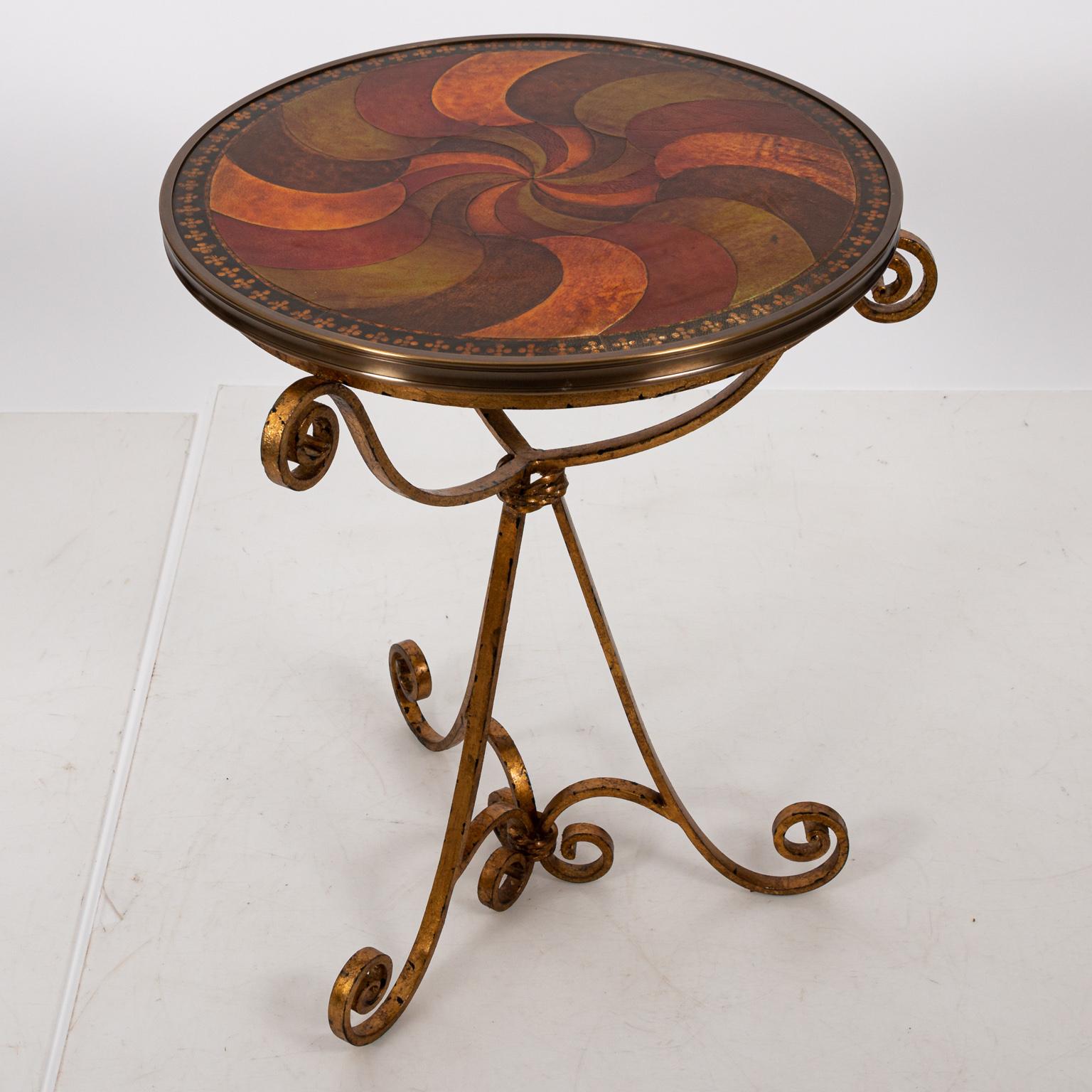 Round swirl embossed leather top table with iron gilt base, circa 1980s. Please note of wear consistent with age and use.