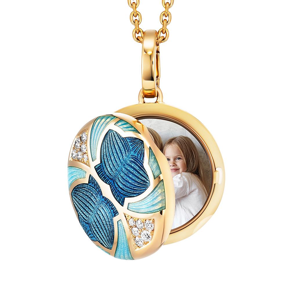 Round locket pendant, 18k yellow gold, Merian Collection, medium blue and opalescent turquoise vitreous enamel, 12 diamonds, total 0.19 ct G VS, brilliant cut

About the creator Victor Mayer
Victor Mayer is internationally renowned for elegant