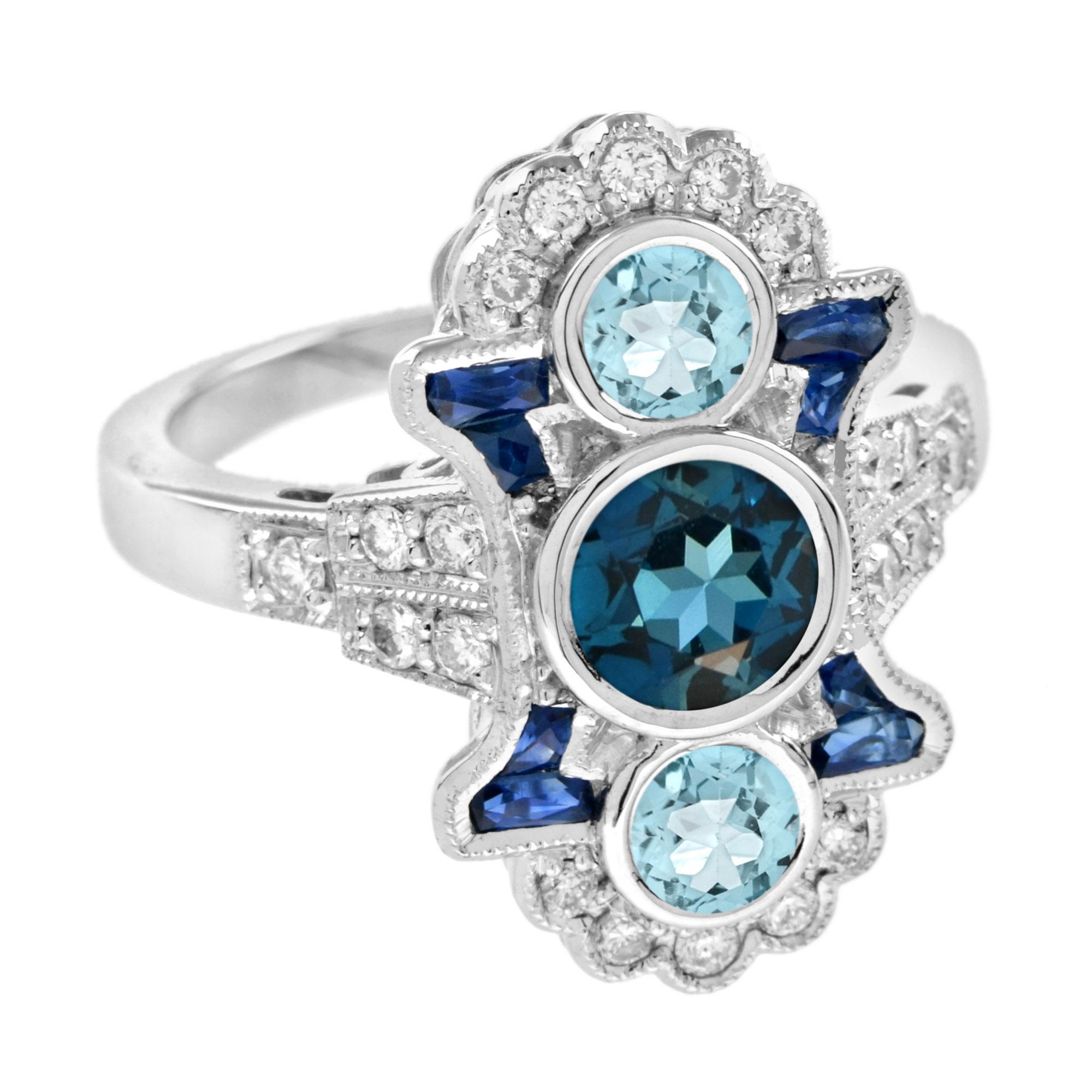 Dieser atemberaubende Ring mit drei Steinen in blauer Farbkombination wurde in Weißgold gefertigt. Ein Londoner Blautopas und zwei Aquamarine, umgeben von kleinen runden Diamanten und Saphiren im französischen Schliff, sitzen vertikal am Finger.