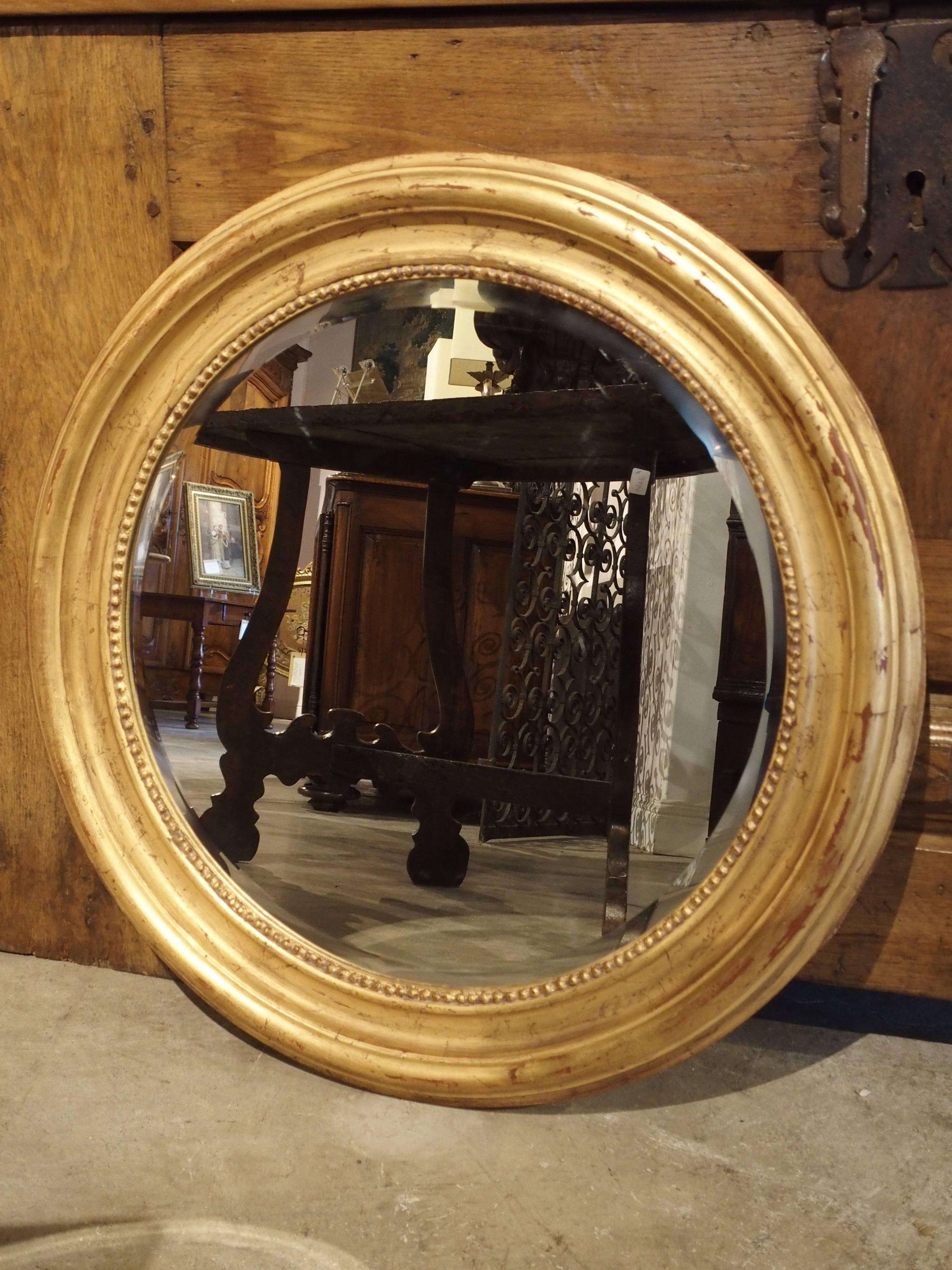 From France, this unusual round, Louis Philippe style mirror has beading surrounding the bevel of the mirror. All period Louis Philippe mirrors are rectangular, so this is a wonderful take on the late 19th century mirror. The frame has raised and