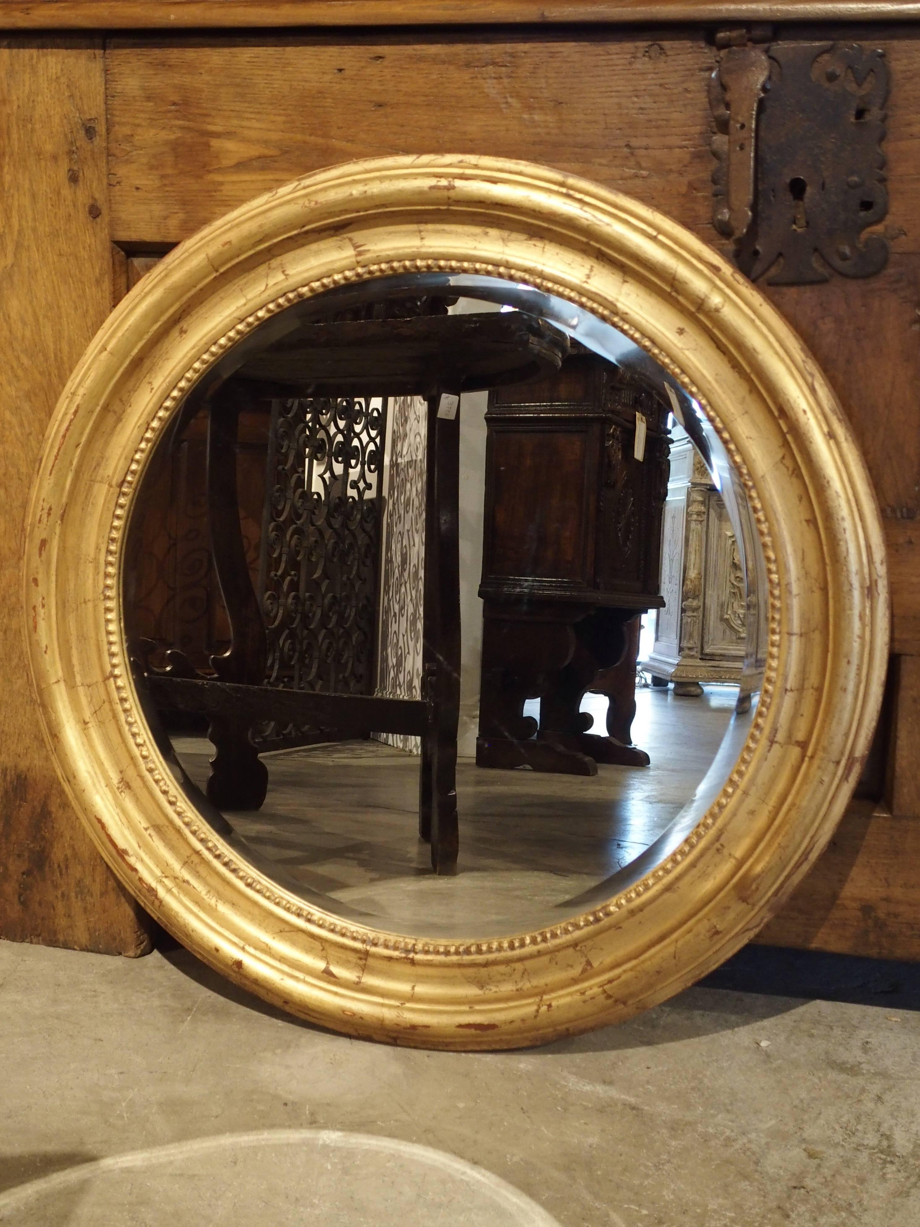 From France, this unusual round, Louis Philippe style mirror has beading surrounding the bevel of the mirror. All period Louis Philippe mirrors are rectangular, so this is a wonderful take on the late 19th century mirror. The frame has raised and