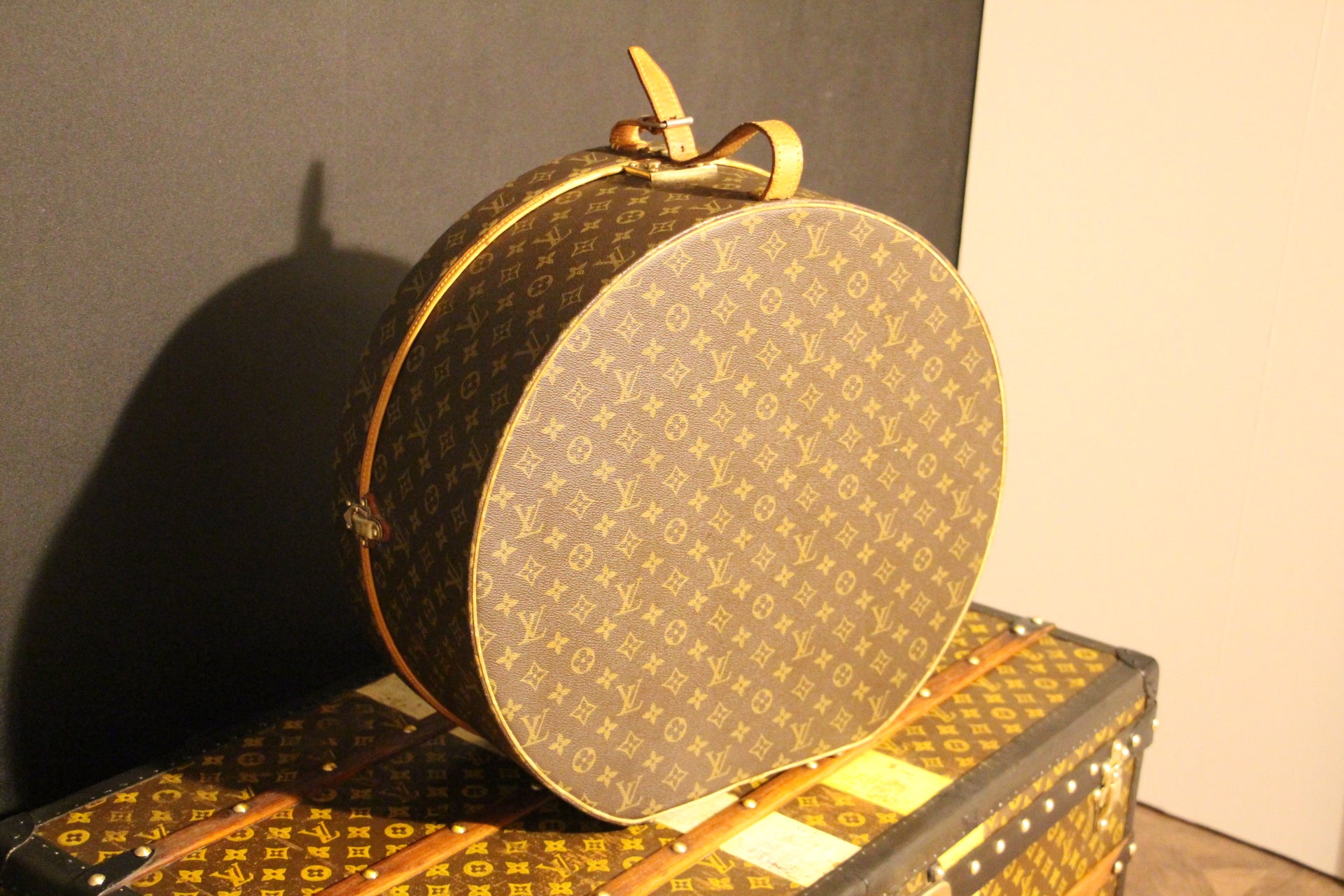 This gorgeous Louis Vuitton hat box features Monogram canvas and natural cowhide reinforcements on a wood structure .It is equipped with an adjustable leather strap . Its leather strap has been replaced by a very sturdy and similar one . It has no