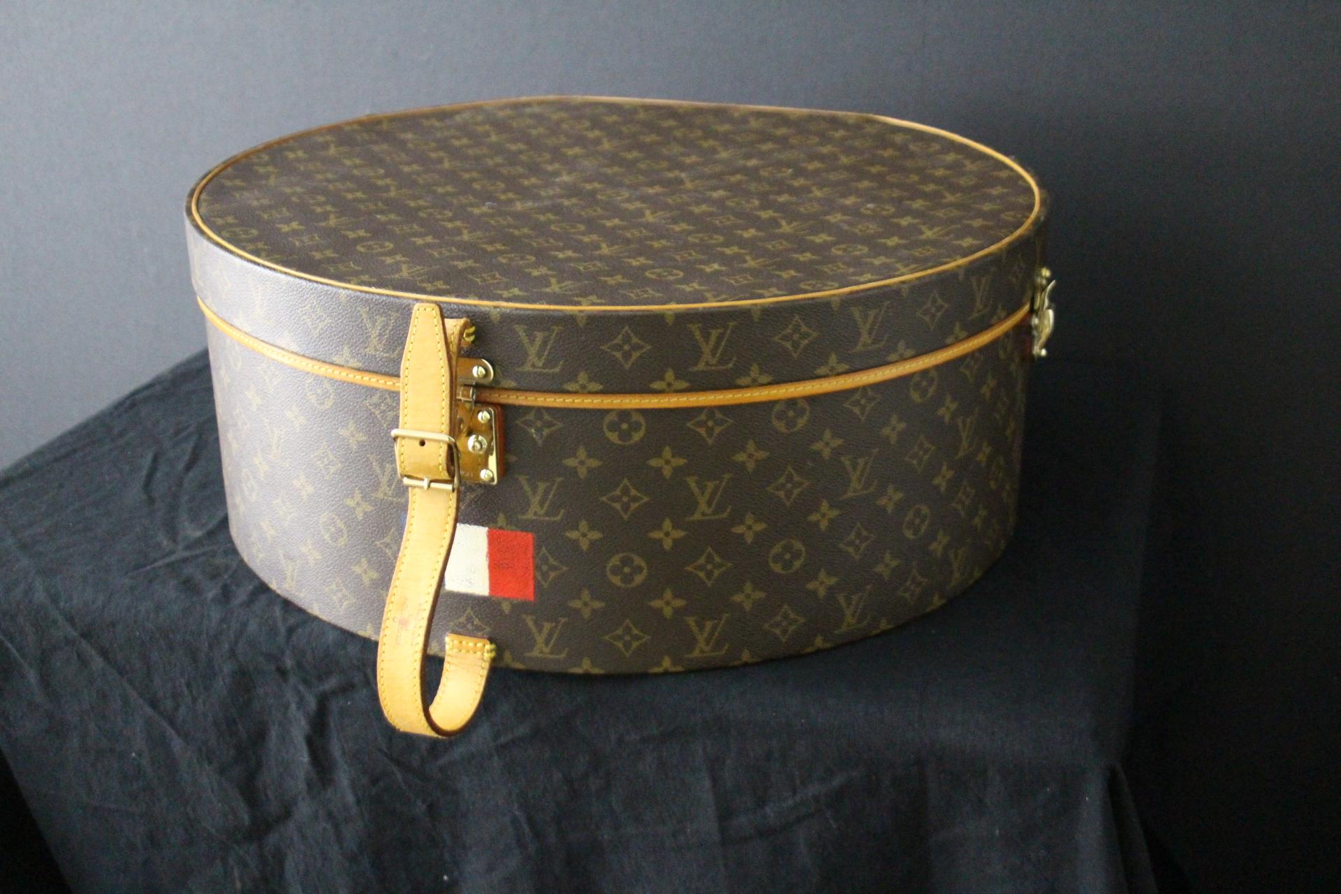 This gorgeous Louis Vuitton hat box features Monogram canvas and natural cowhide reinforcements on a wood structure .It is equipped with an adjustable leather strap . It has a customized hand painted French flag. It has a Louis Vuitton stamped brass